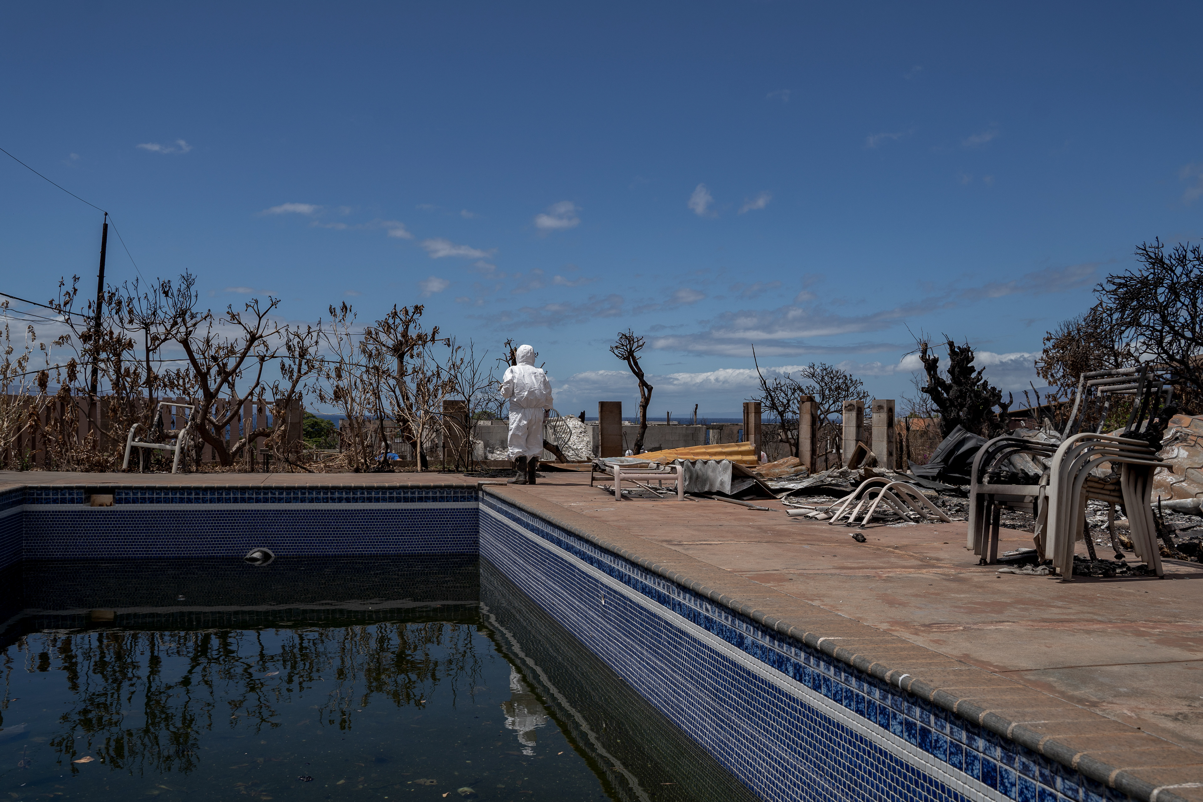 Leola Vierra walks through her home that was destroyed by the wildfire in August, on Tuesday, Sept. 26, 2023, in Lahaina, Hawaii. (AP Photo/Mengshin Lin)