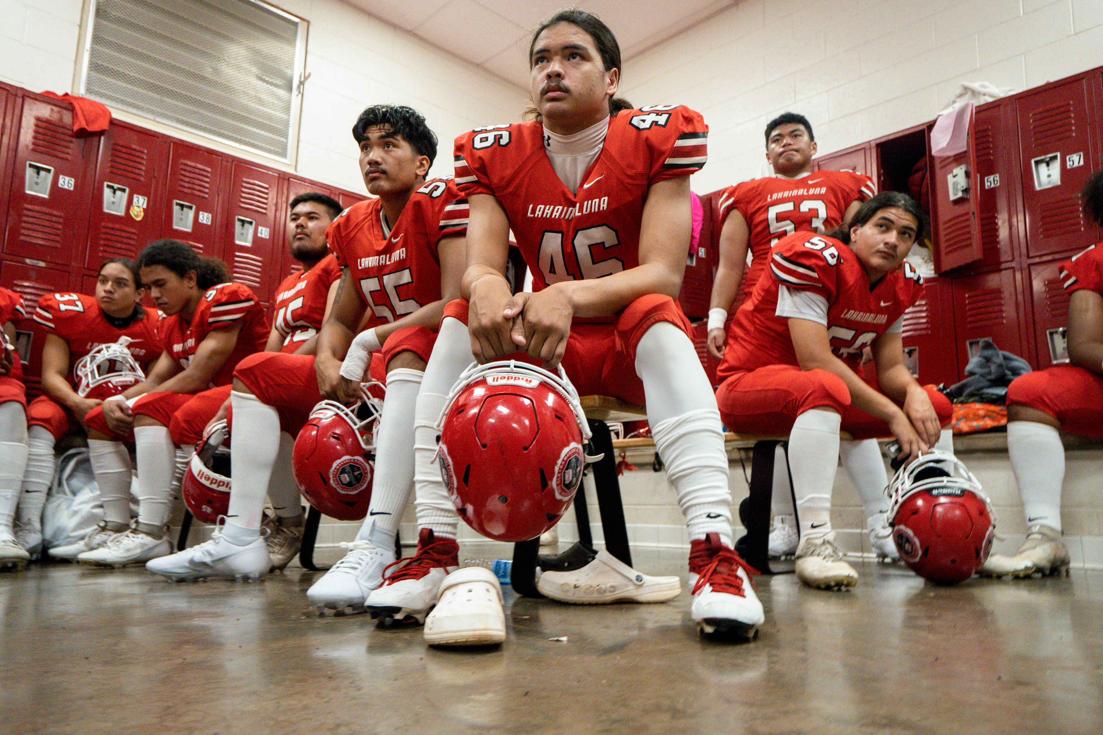 Lahainaluna football team players listens to co-head coach Dean Rickard before their homecoming game at Sue D. Cooley Stadium on Saturday, Oct. 21, 2023, in Lahaina, Hawaii. (AP Photo/Mengshin Lin)
