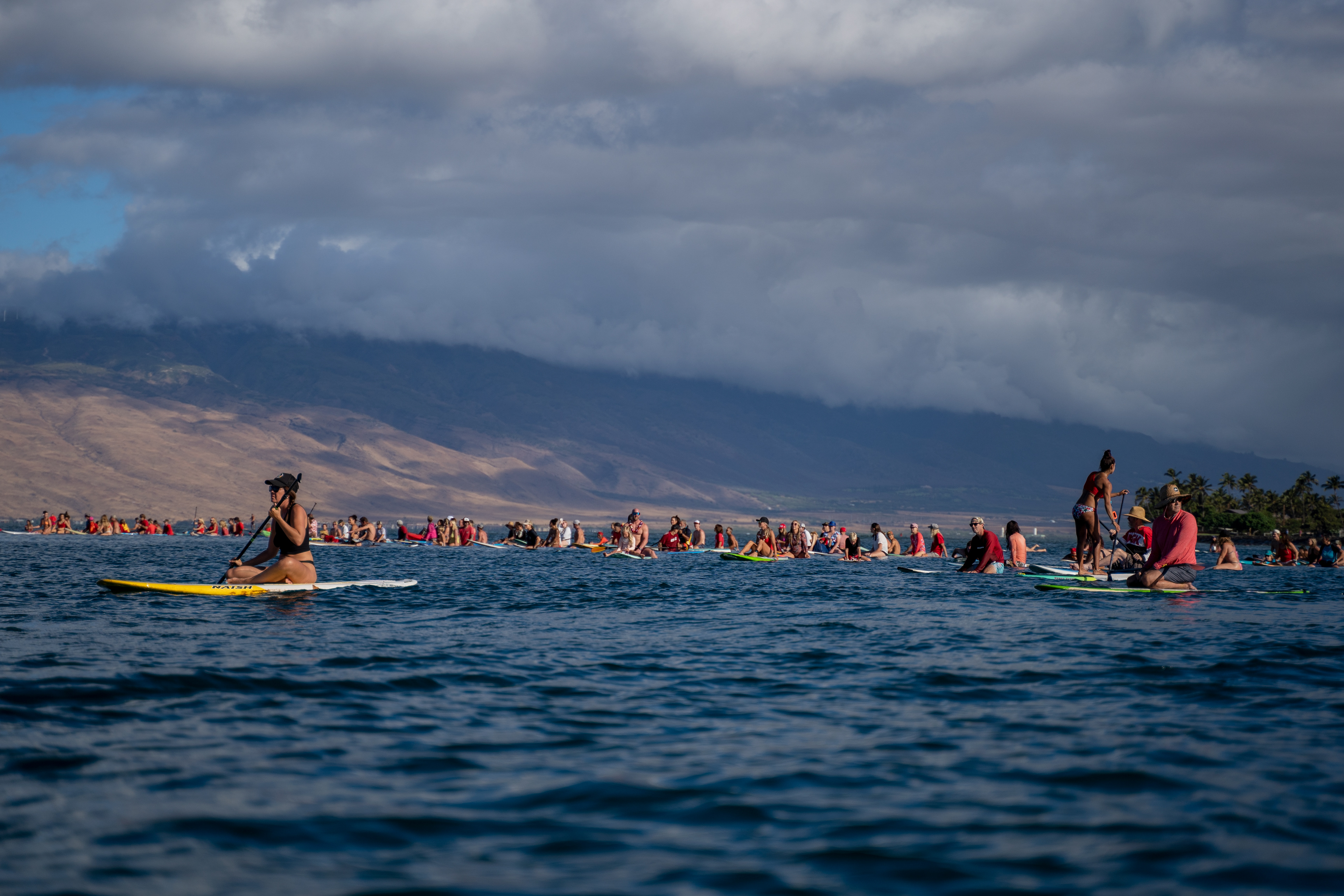 Kihei, HI - SEPTEMBER 8: Dozens surfers gather for a memorial paddle out on the one-month anniversary of the Lahaina Fire at Kalama Beach Park in Kihei, Hawaii on September 8, 2023. (Photo by Mengshin Lin for The Washington Post)