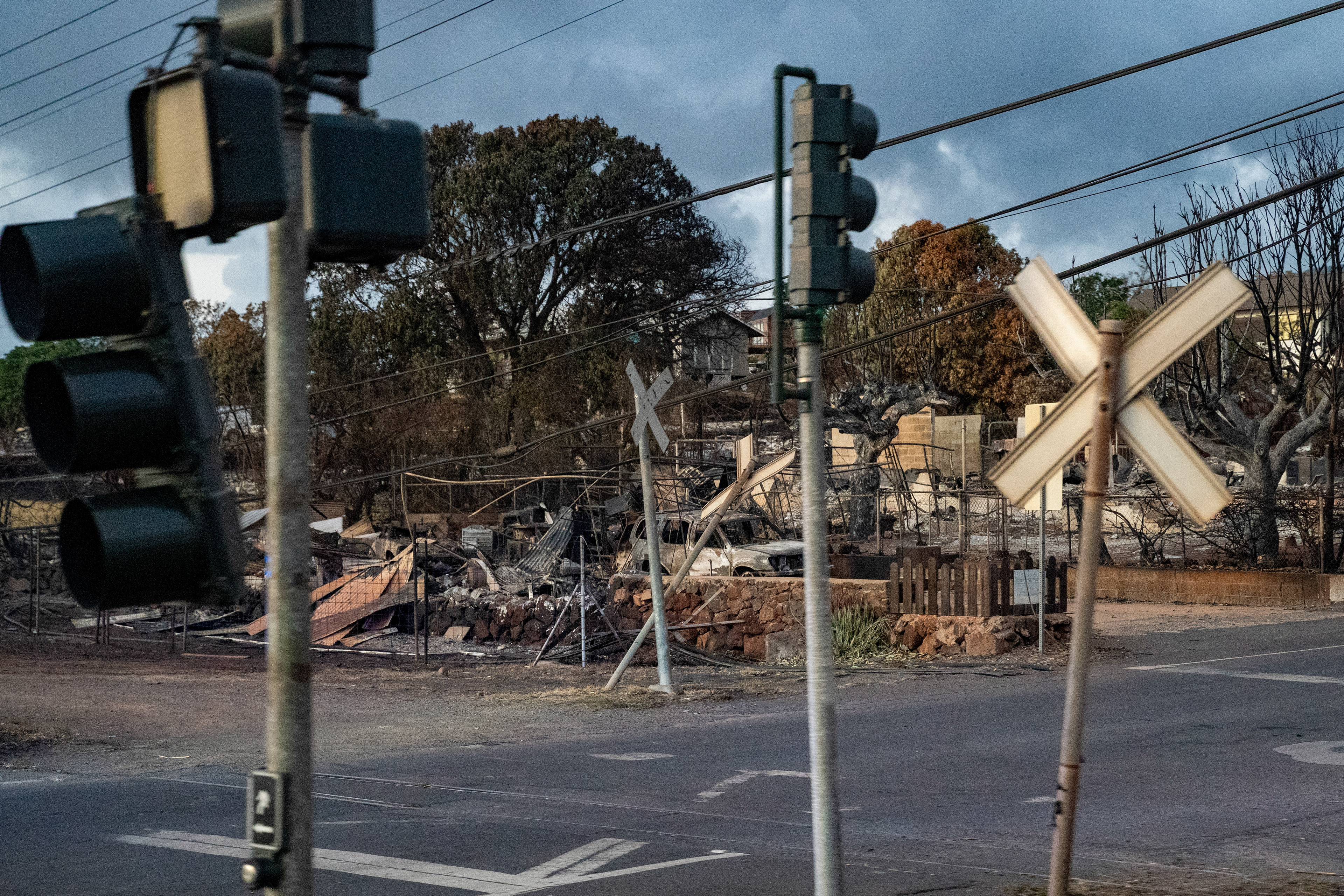 Lahaina, HI - AUGUST 23: A fallen signal sign and burned houses and cars are pictured on Honoapiilani Highway in Lahaina, Hawaii on August 10, 2023. (Photo by Mengshin Lin for The Washington Post)
