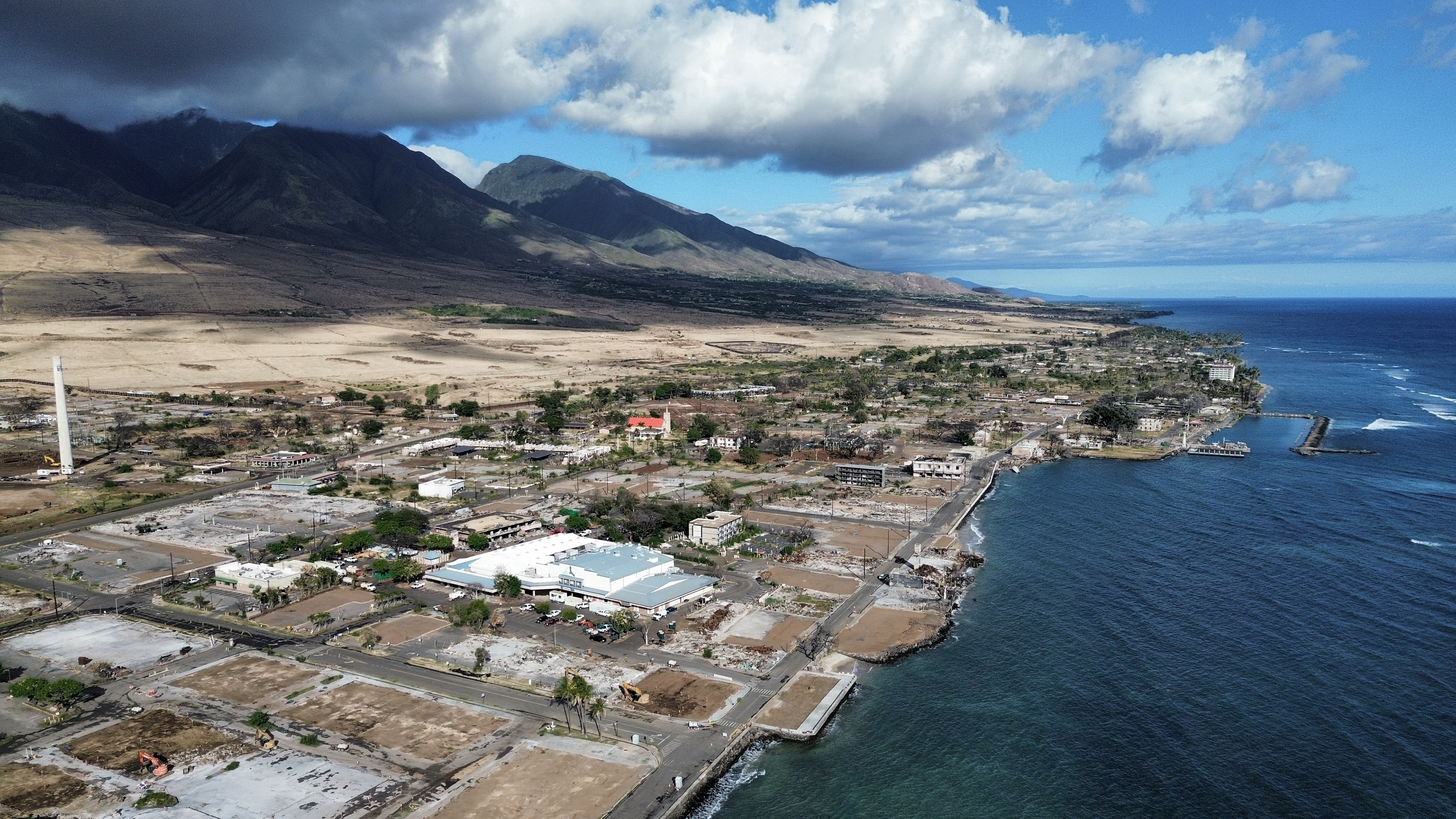 A general views of Front Street shows the primary debris from last year’s wildfire being removed for commercial properties on Wednesday, June 26, 2024, in Lahaina, Hawaii. (AP Photo/Mengshin Lin)