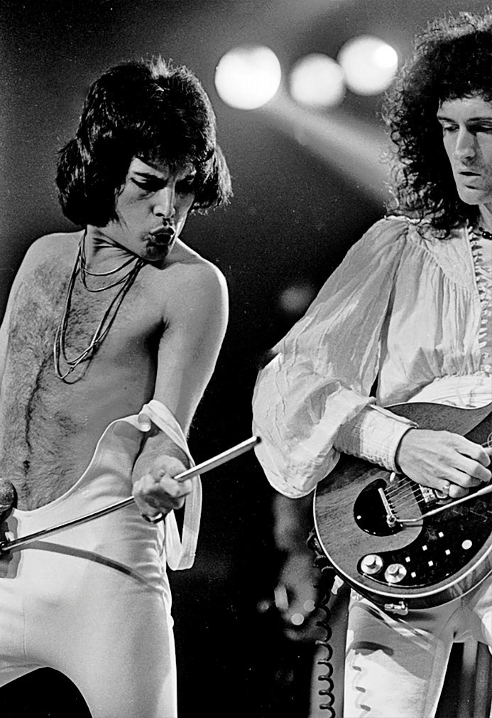 Freddie Mercury & Brian May perform with Queen at Madison Square Garden. Feb 1977.