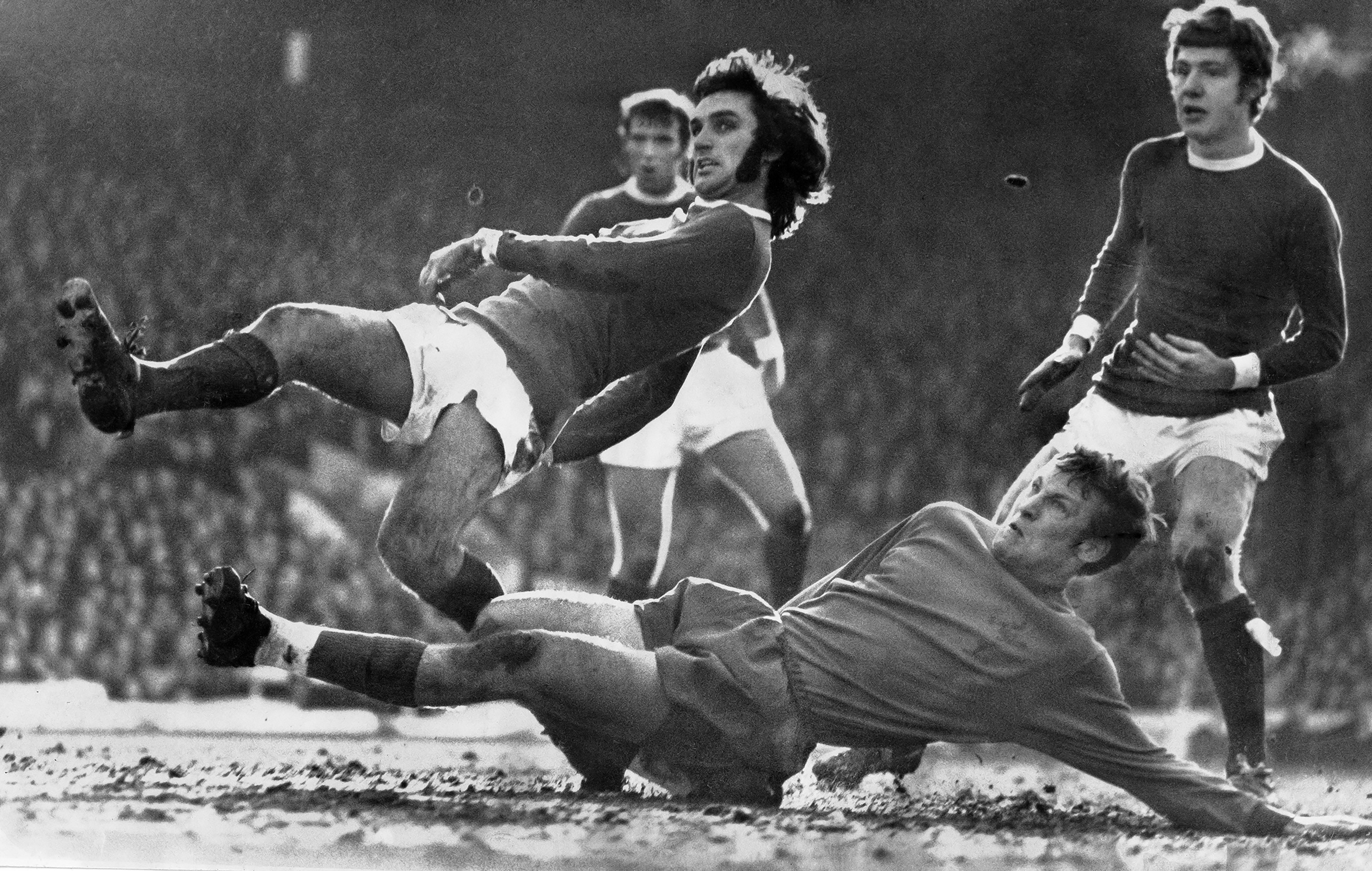 Manchester, UK,. March 14, 1970. "Dancing in the Light." Manchester United's George Best slips a tackle from Crystal Palaces' David Payne.e.