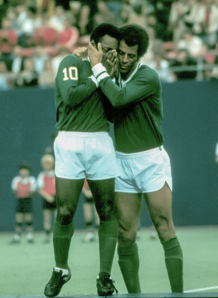 Rutherford, NJ. October 1, 1977. Pele reacts to seventy thousand adoring fans prior to playing his last game at Giants Stadium. Colleague Carlos Alberto consoles him.