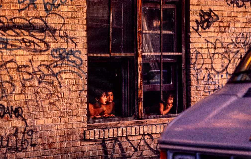 South Bronx, Ny; 1989. At the height of the out of control "crack epidemic" the drug plagued South Bronx became the centre of attention for the NYPD. Here, in this mostly Latino part of the South Bronx small kids watch activities involving dealers and police officers play-out under the late evening summer light.