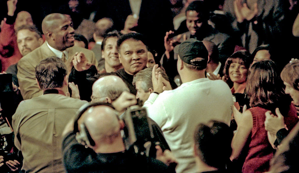 Auburn Hills, Michigan. October 20, 2000. Muhammad Ali, surrounded by family and friends including NBA Superstar Magic Johnson attends daughter Leila's winning fight with Kendra Lenhart. on the Mike Tyson v Andrew Golota card.