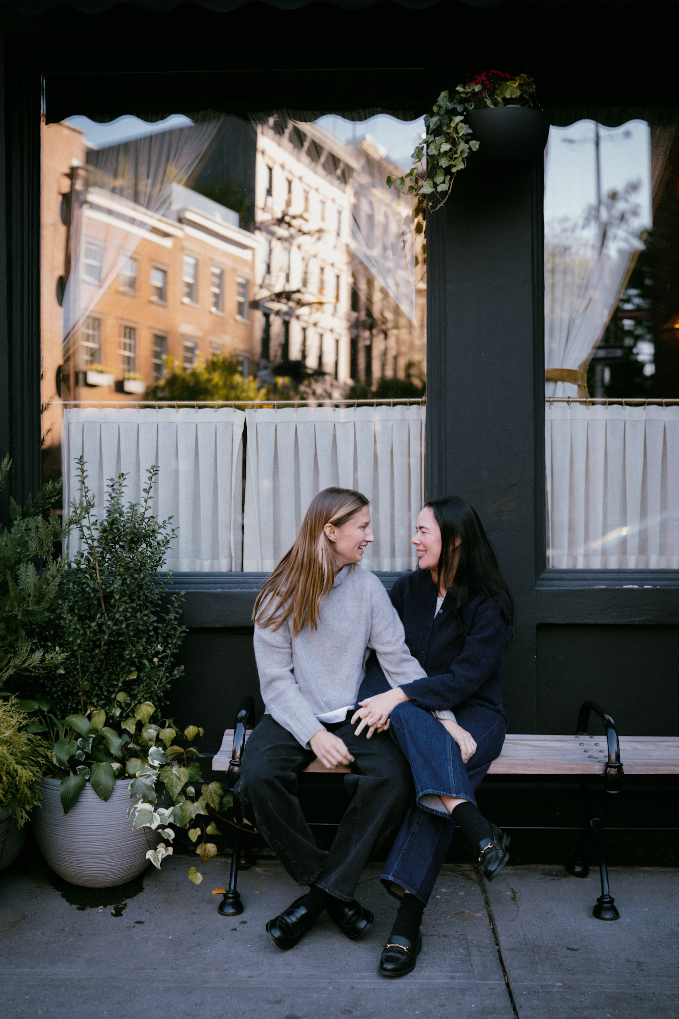 Couple sits in front of the Golden Swan in the West Village.
