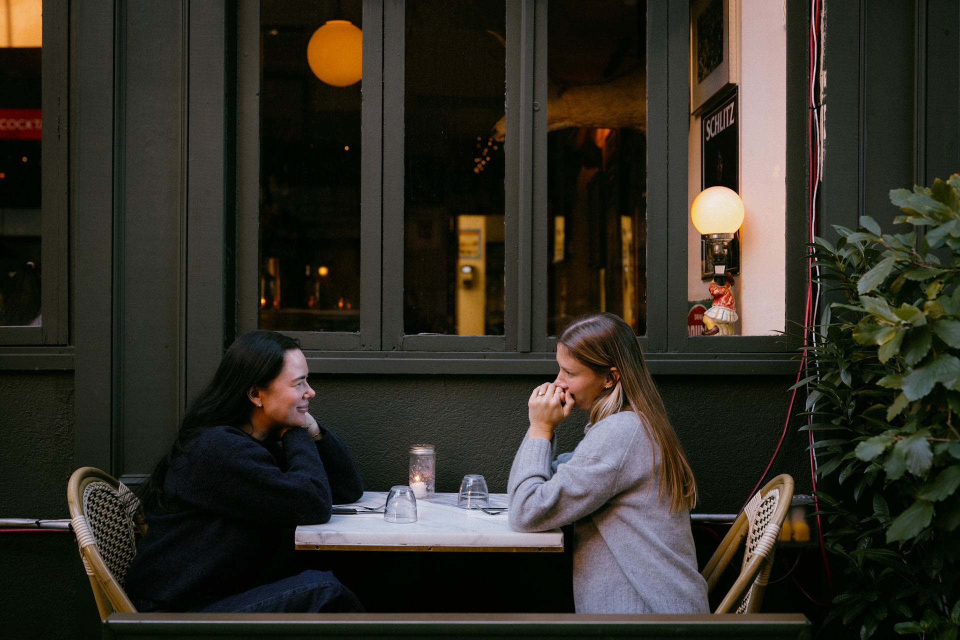 Couple looks at each other across table at a West Village cafe.