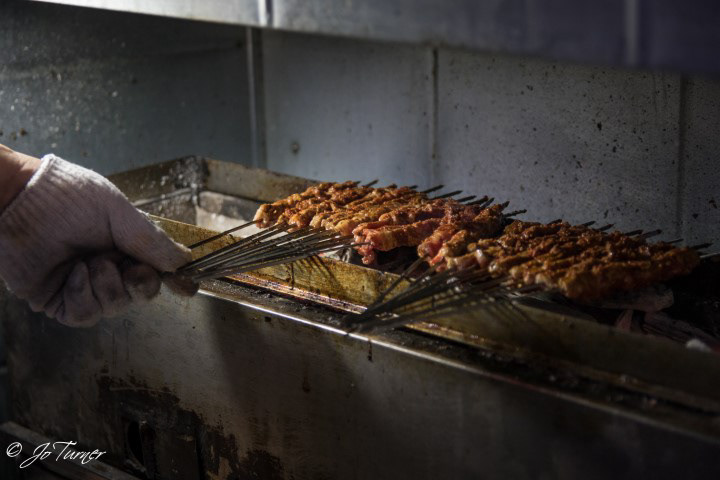 Precooking lamb skewers outside Songhwa Yanggochi near Konkuk University in Seoul