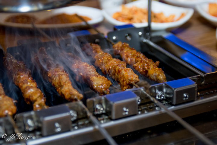 Lamb skewers are cooked at the table at Songhwa Yanggochi near Konkuk University in Seoul