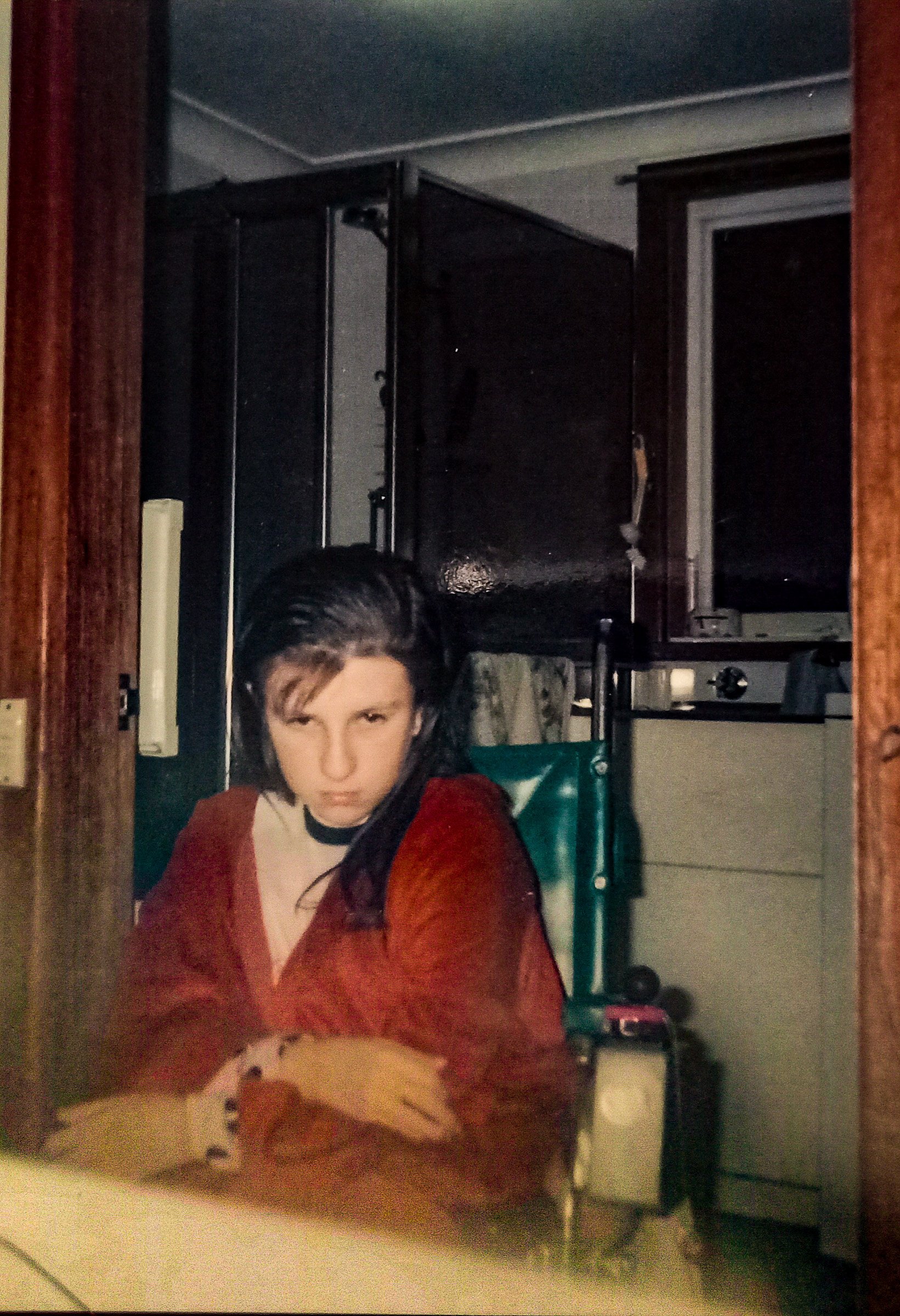 A photo of Malissa as a teenager, sitting in her wheelchair and scowling at the camera
