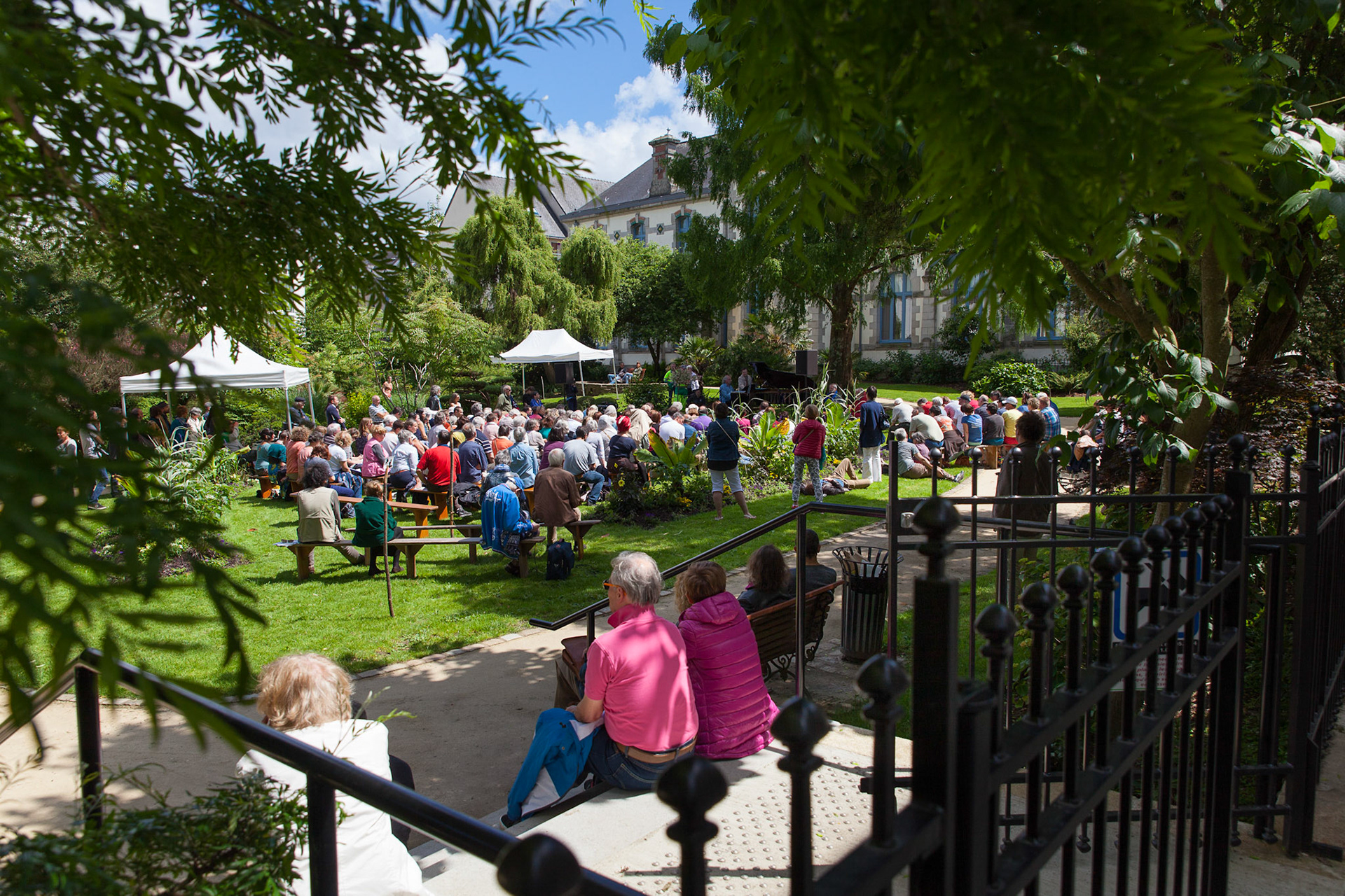 Le public est installé sur des meules de paille ou des bancs dans la magnifique cadre des jardins du pôle Max Jacob.
