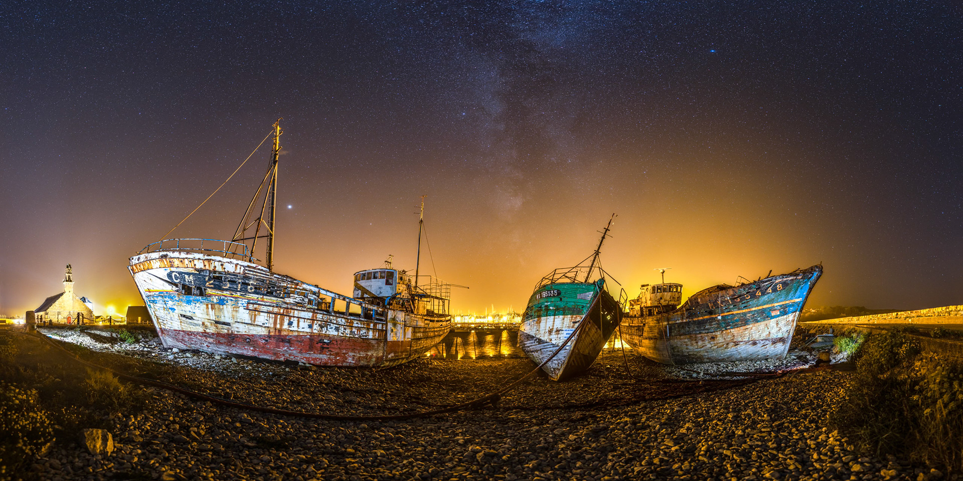 J'ai éclairé les épaves du port de Camaret-sur-Mer à l'aide du flash de mon smartphone. Avec cette lumière d'un blanc pur, les épaves contrastent bien avec l'atmosphère engendrée par cette débauche de lumière orange. Mais la Voie lactée peine à se faire visible.