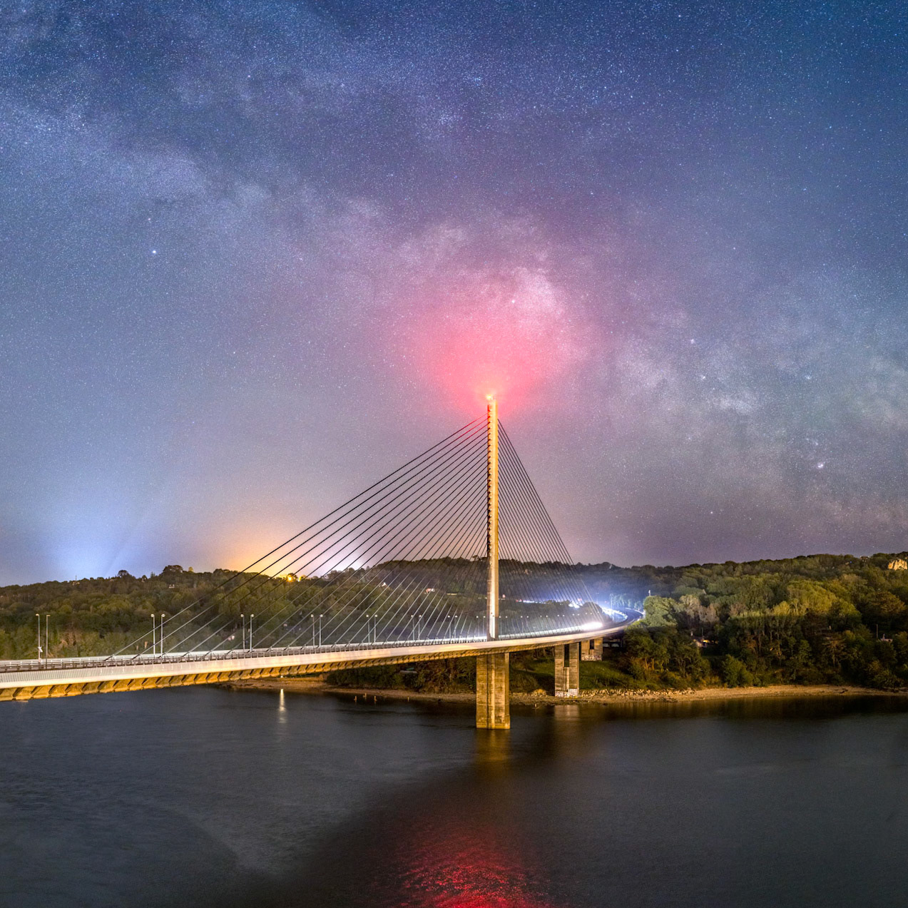 Je me suis installé sur le Pont Alert-Louppe pour profiter de ce point de vue sur le Pont de l'Iroise en direction du sud-est, et ce, pour pouvoir immortalier le passage de la Voie lactée derrière l'édifice. Je profite aussi du passage de plusieurs véhicules qui offrent des lumières intéressantes à l'extrémité du pont qui mène vers Plougastel-Daoulas.