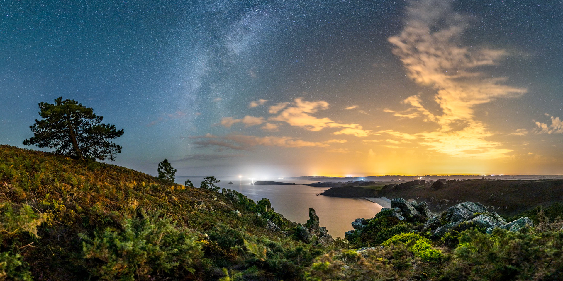 La silhouette sombre de l'Île de l'Aber est typique du paysage qui s'offre à nous depuis la Pointe du Guern. Juste au-dessus de l'îlot, le halo lumineux blanc du Port de Morgat (et son phare un peu plus haut à gauche). La Voie lactée étant verticale (pleine ouest), j'avais besoin de ce joli pin tout à gauche et des nuages à droite (éclairés surtout par la ville de Brest située en dessous), sans quoi, le ciel aurait été trop vide.