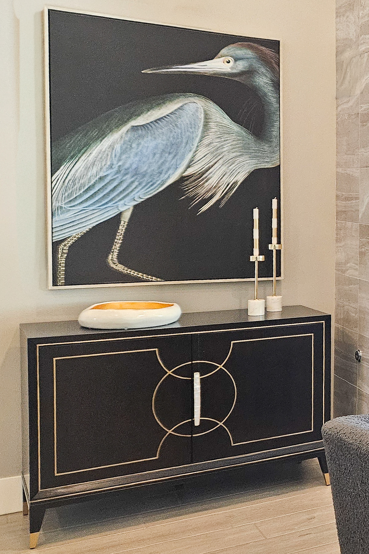 The organic grace of nature inspired art set against the sharp technical precision of a mahogany and gold-leaf credenza.