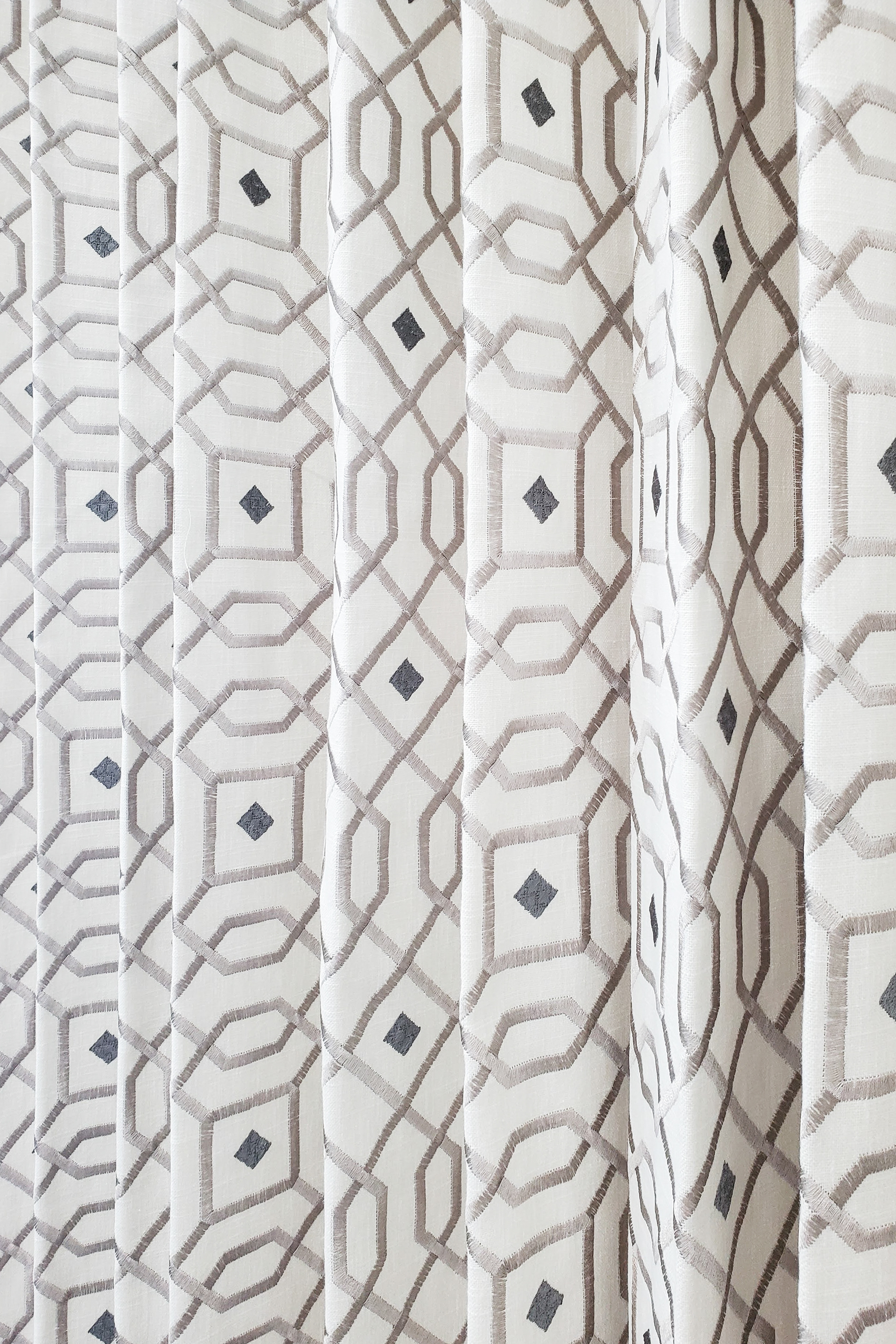 A rhythmic display of geometric embroidery and tactile line work, bridging the gap between metallic sheen and soft neutrals.