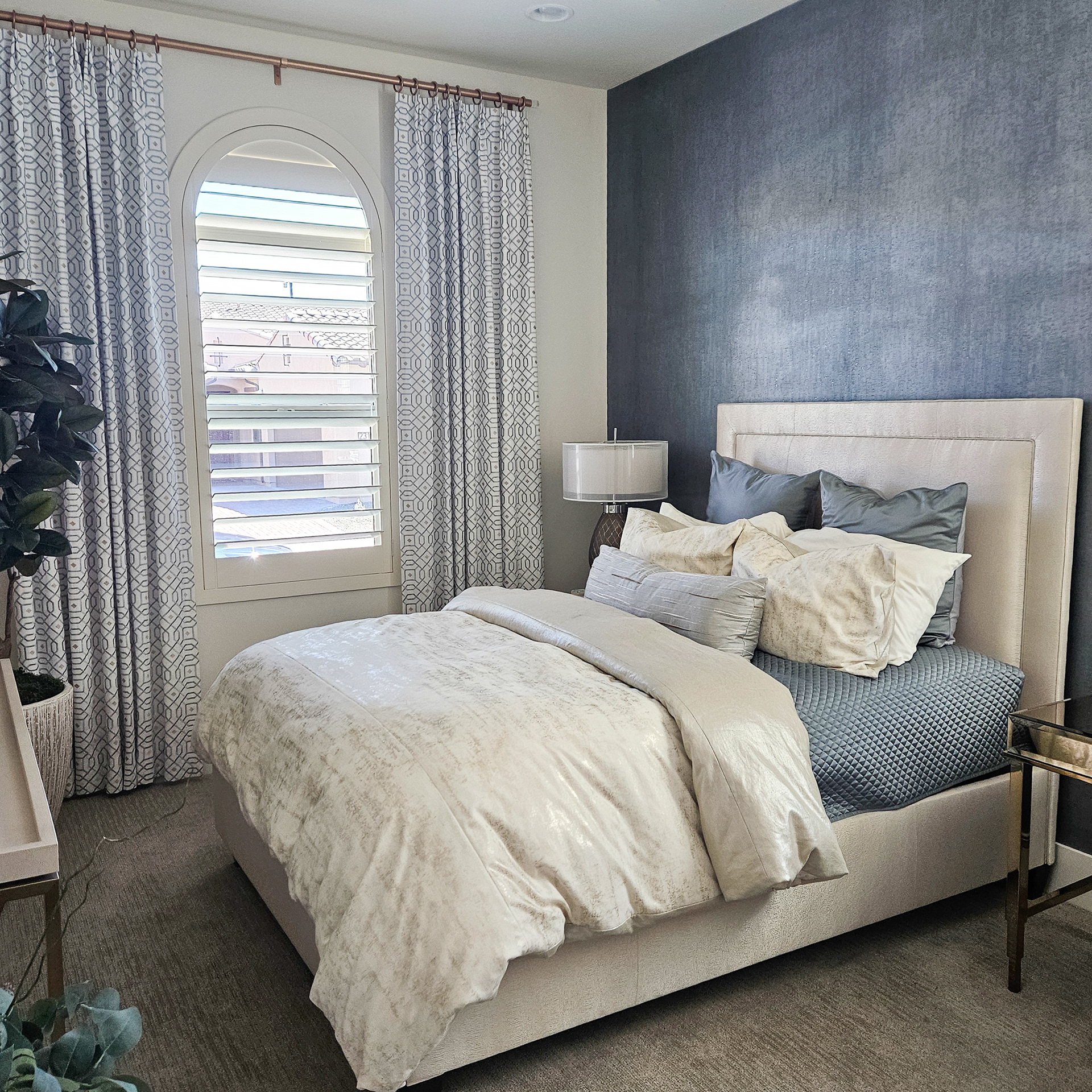 Deep mist-blue wallcoverings provide a sophisticated backdrop that amplifies the quiet radiance of golden accents.