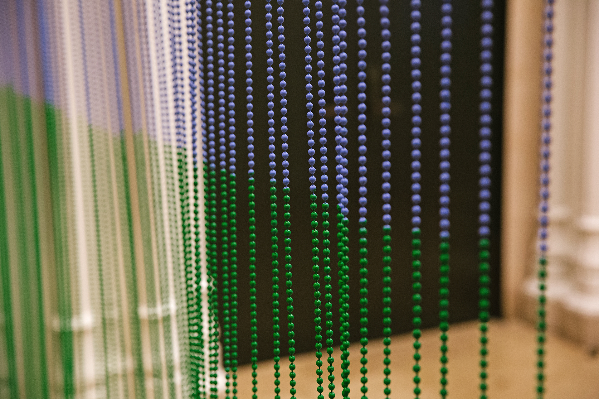 An interration of "Paradise of Greenery" at the Jewish Museum in New York. A close up of a beaded curtain shows blue and green beads