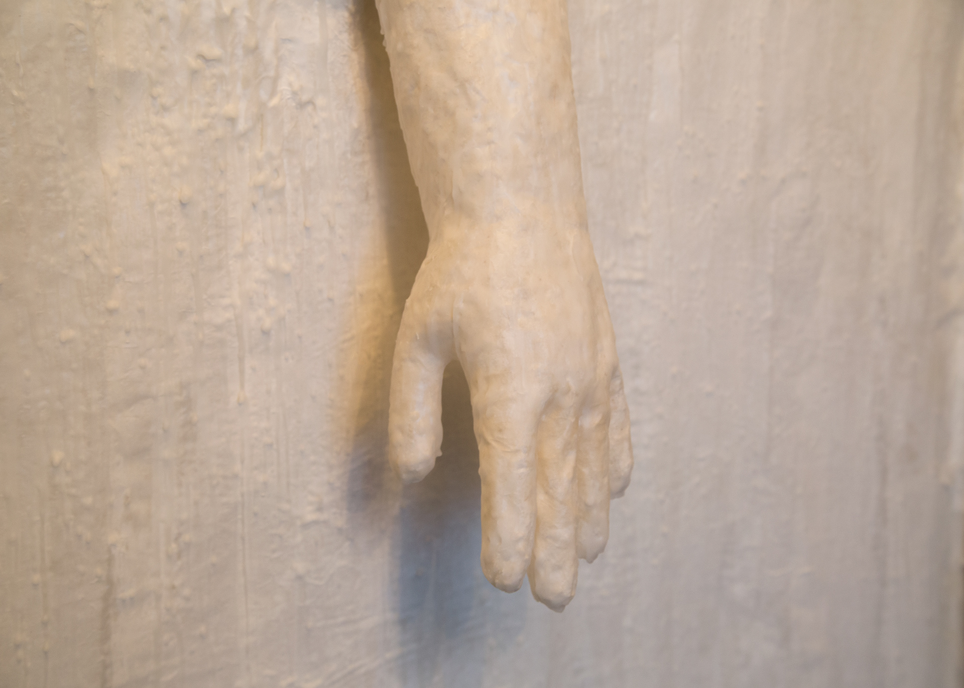 Detail of paper and wax membrane / wall structure with a paper and wax quarantine glove pushing through.