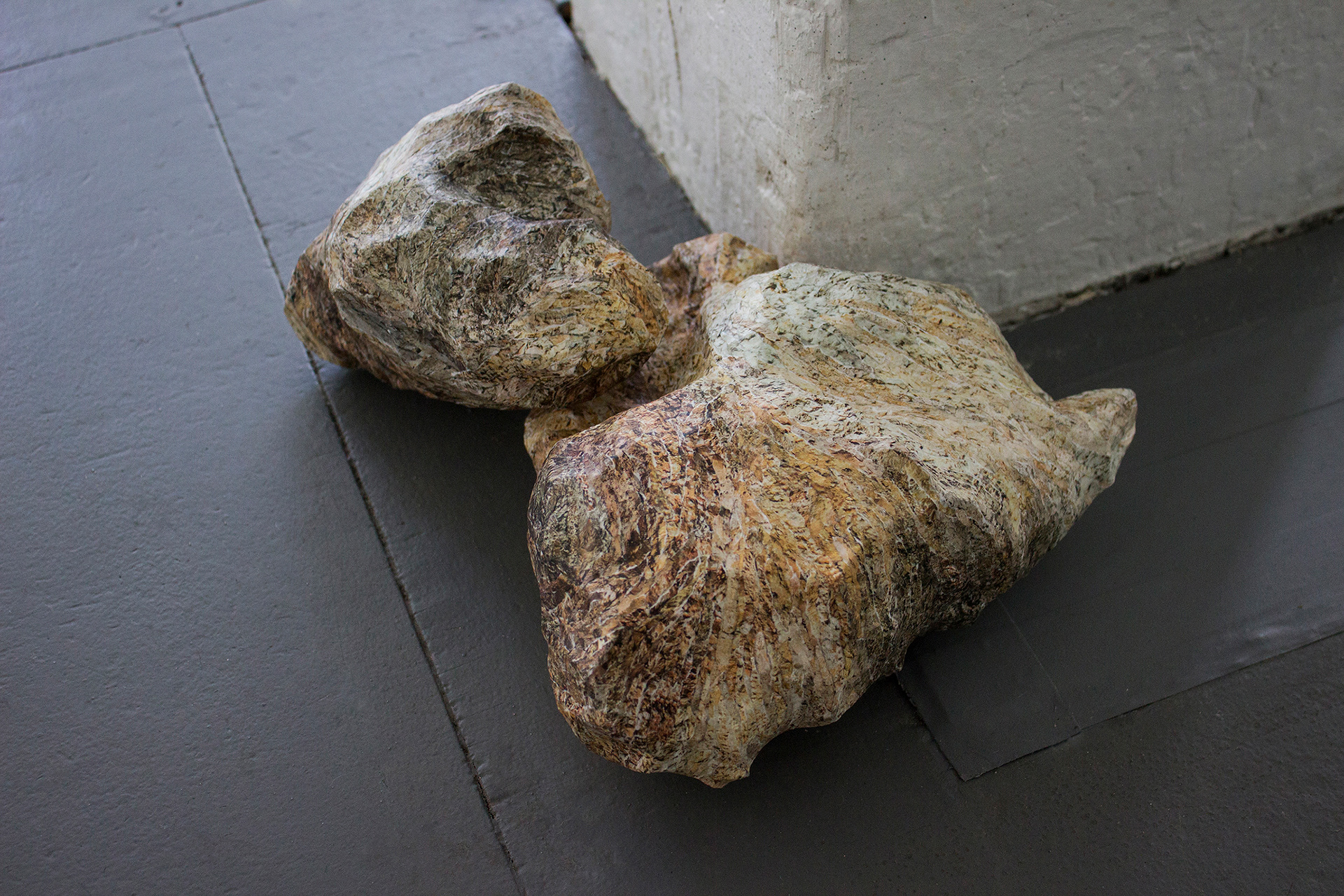 "Their Natural State" Two Rubble sculptures sit at the base of a column