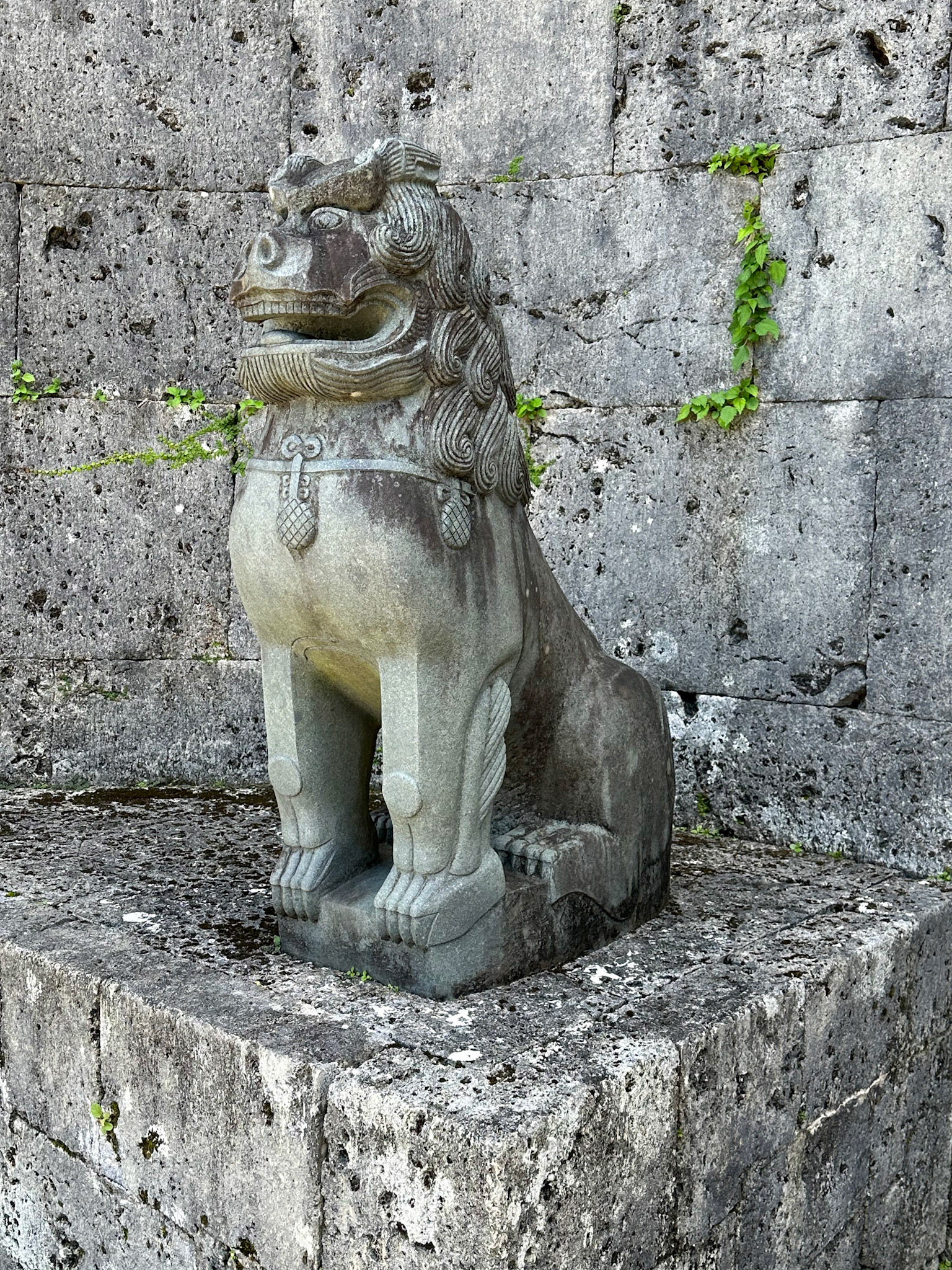 A Shisa standing in front of the Kankai-mon gate
