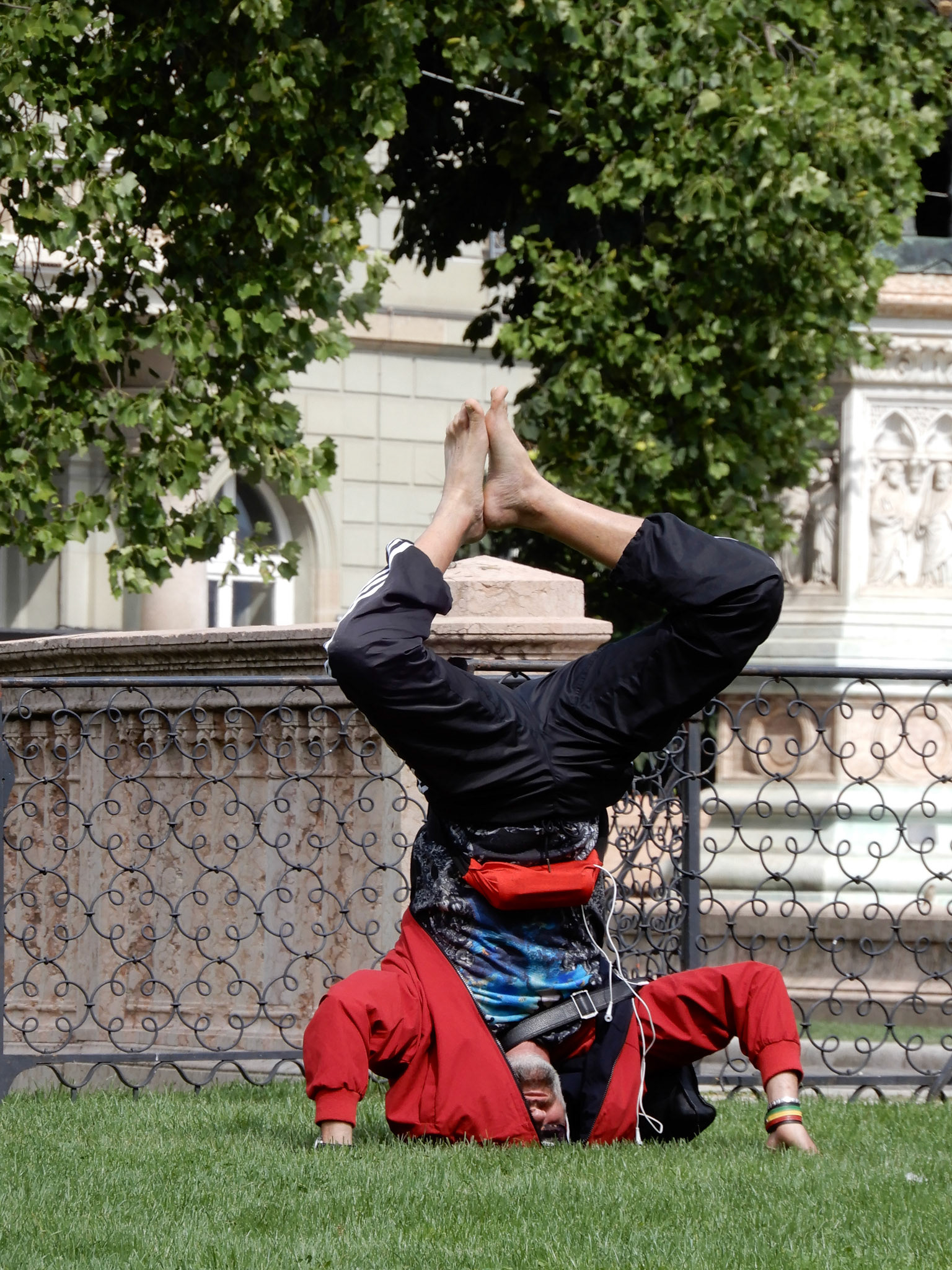 Man practicing yogo on the lawn of the Brunswick Monument, a mausoleum built to commemorate the life of Charles II, Duke of Brunswick.