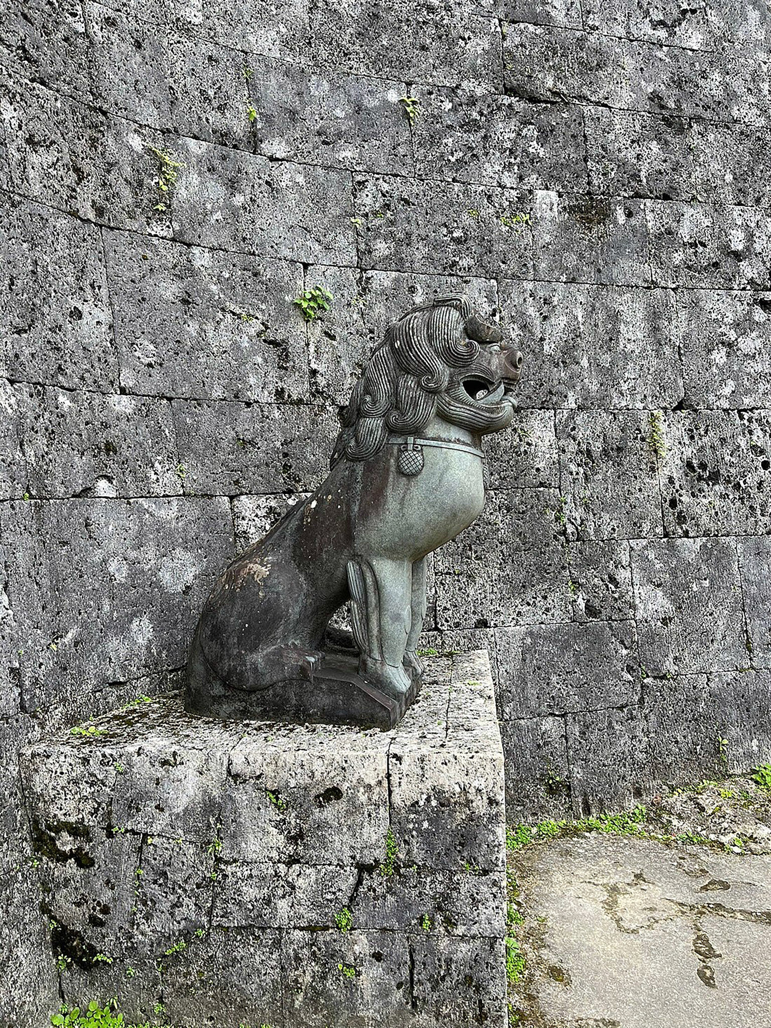 A Shisa standing in front of the Kankai-mon gate