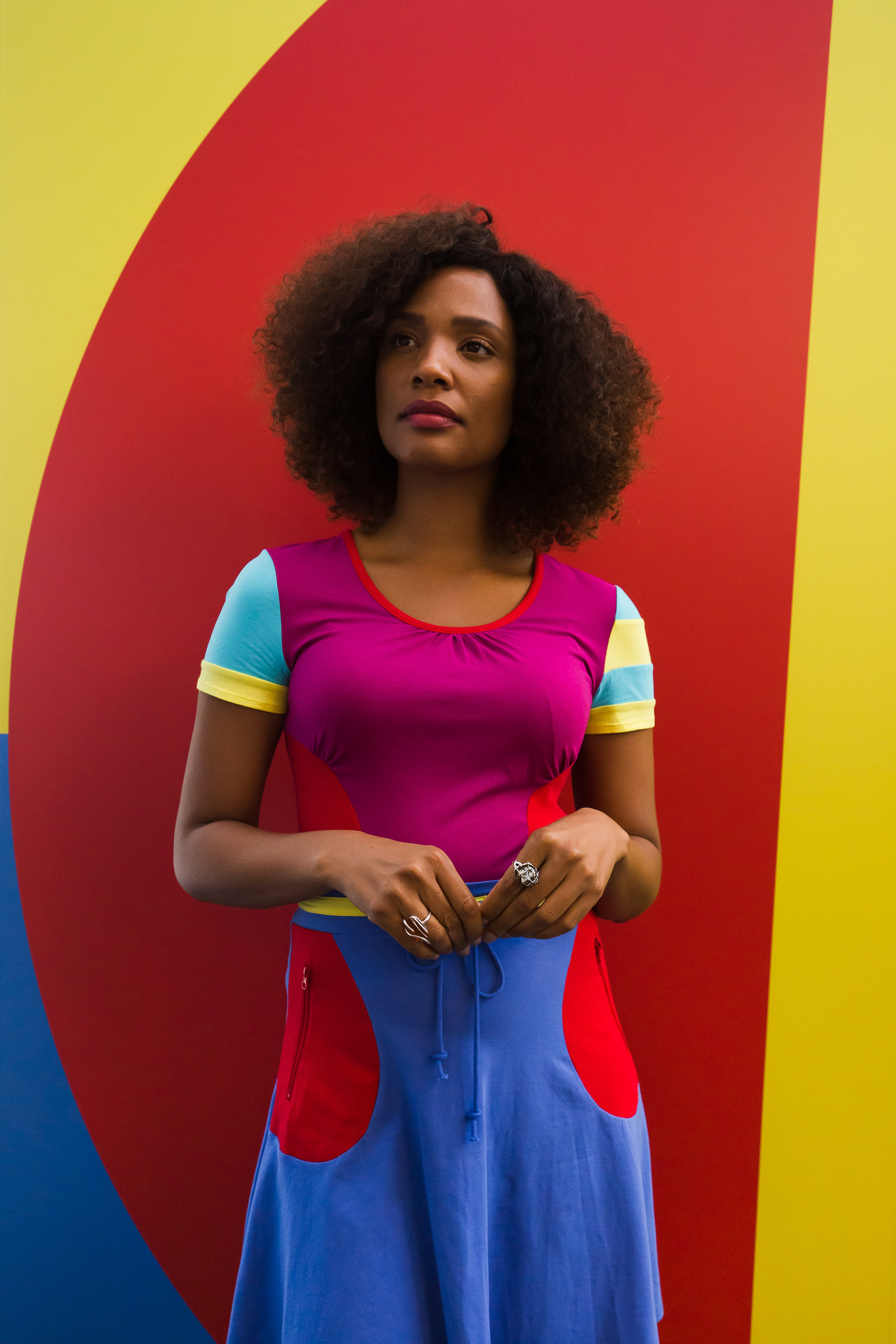 Tamyko V wearing Stephen Burrows dress in front of inspired backdrop