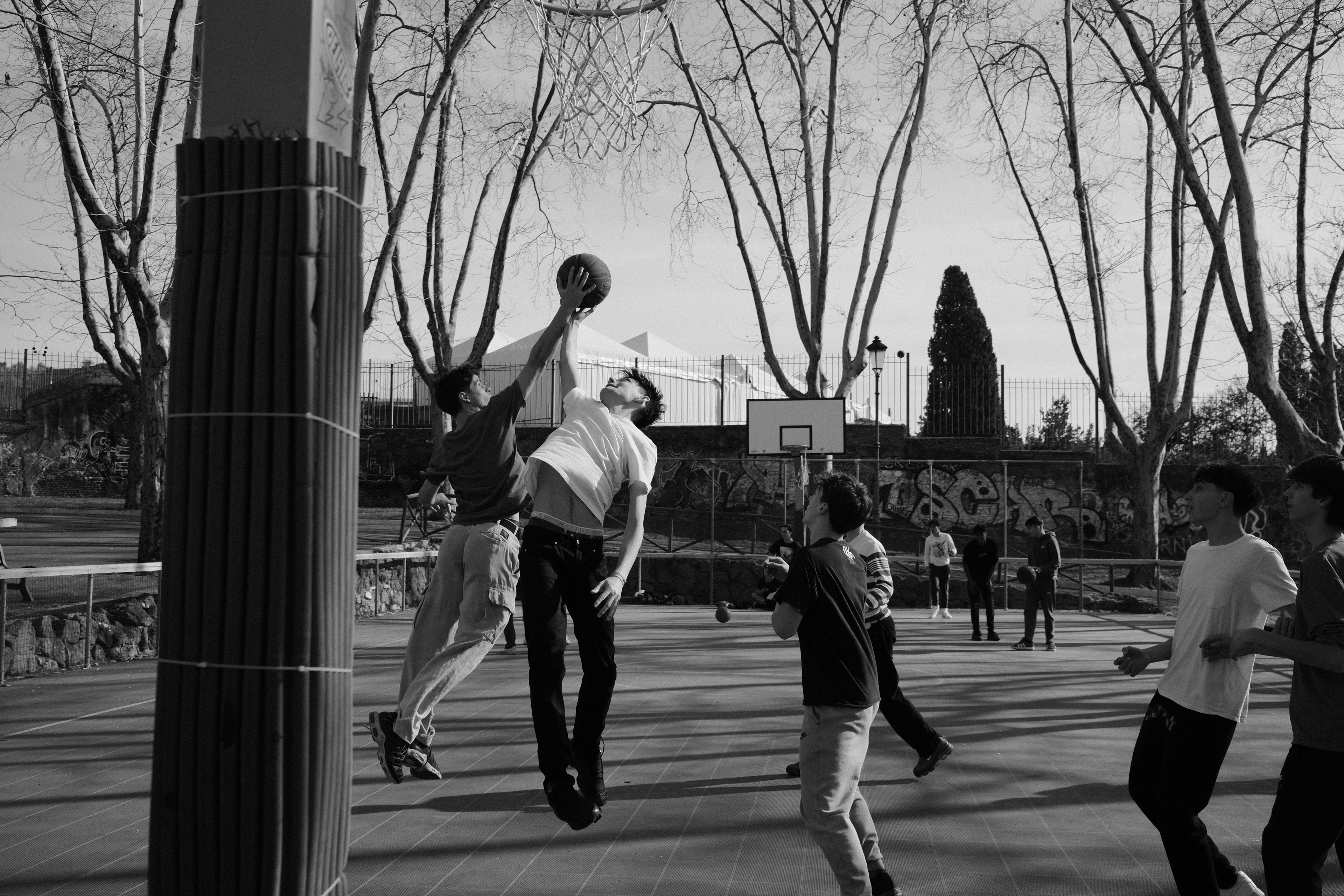 Teenagers playing basketball. Rome, Italy 2024.