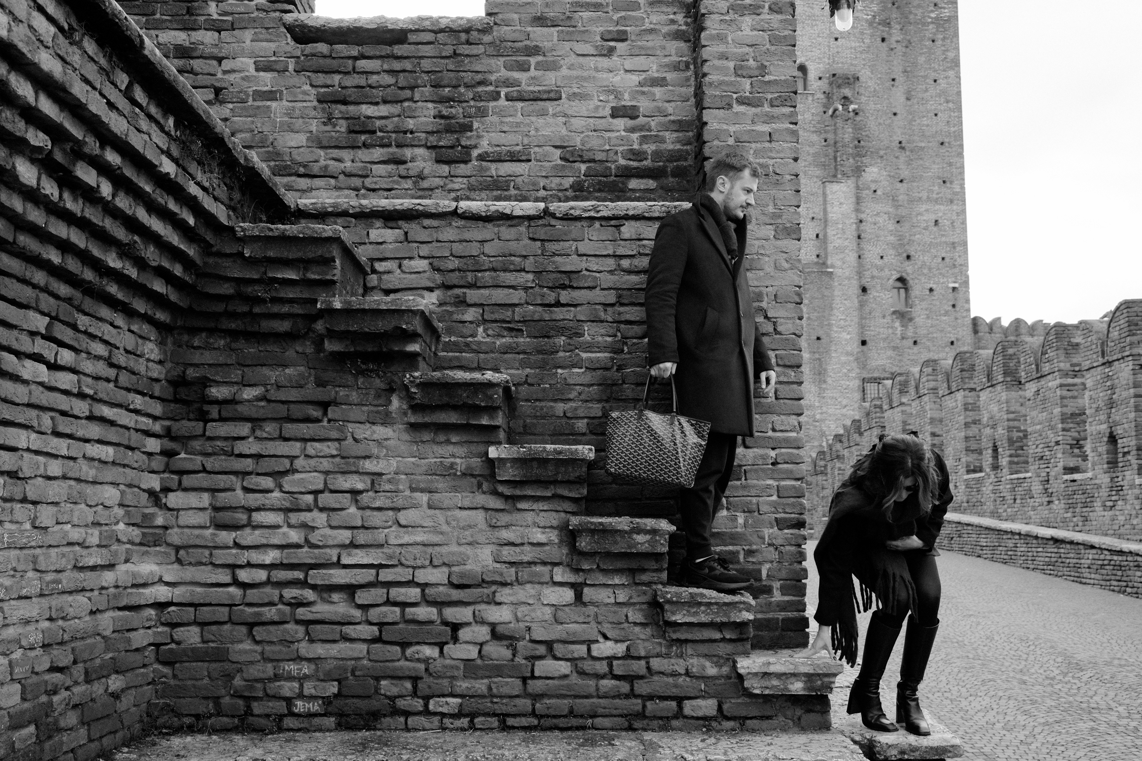 A couple is coming down the stairs. Verona, Italy 2025.