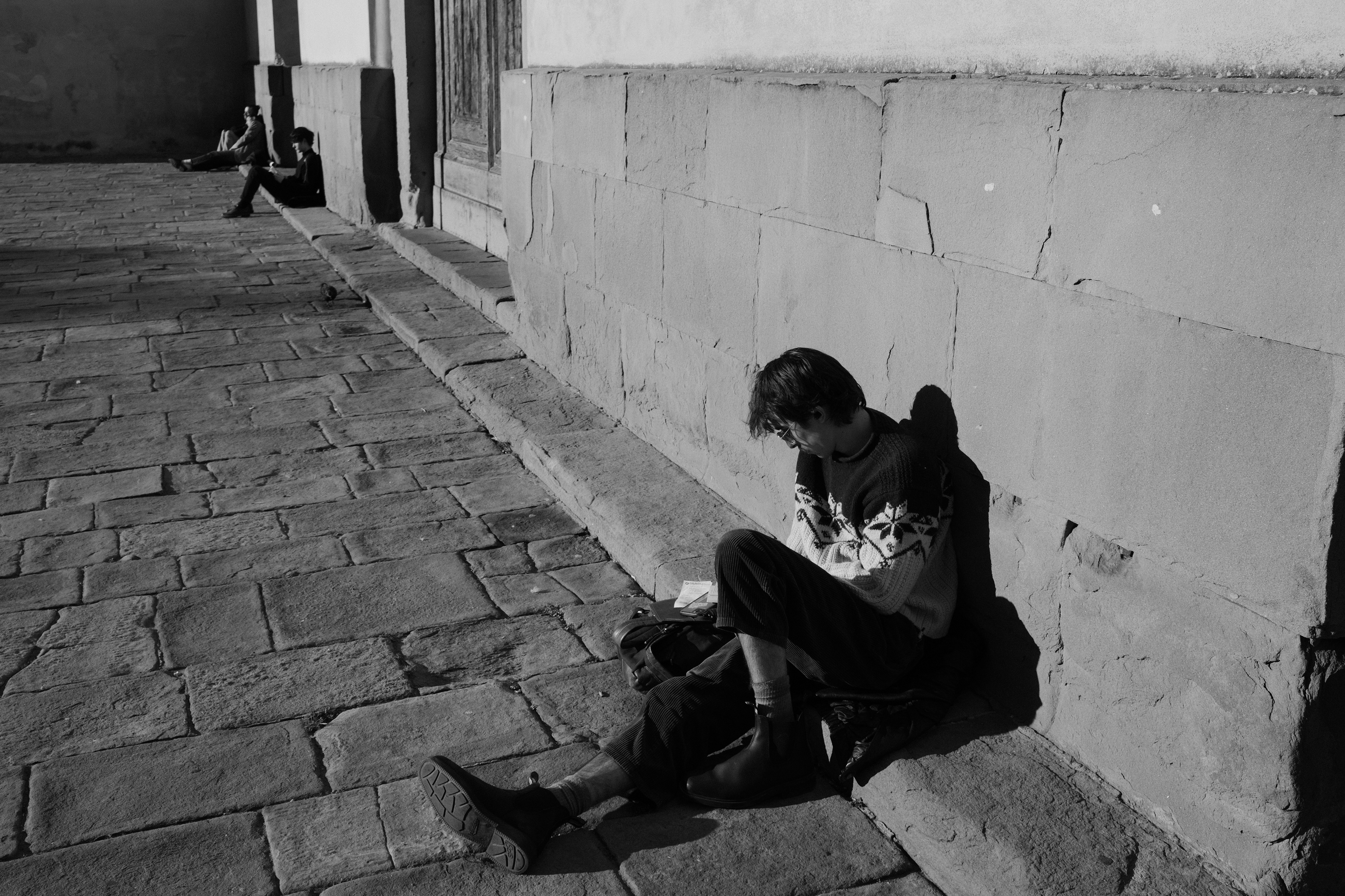 A young man reading in the sun. Florence, Italy 2024.
