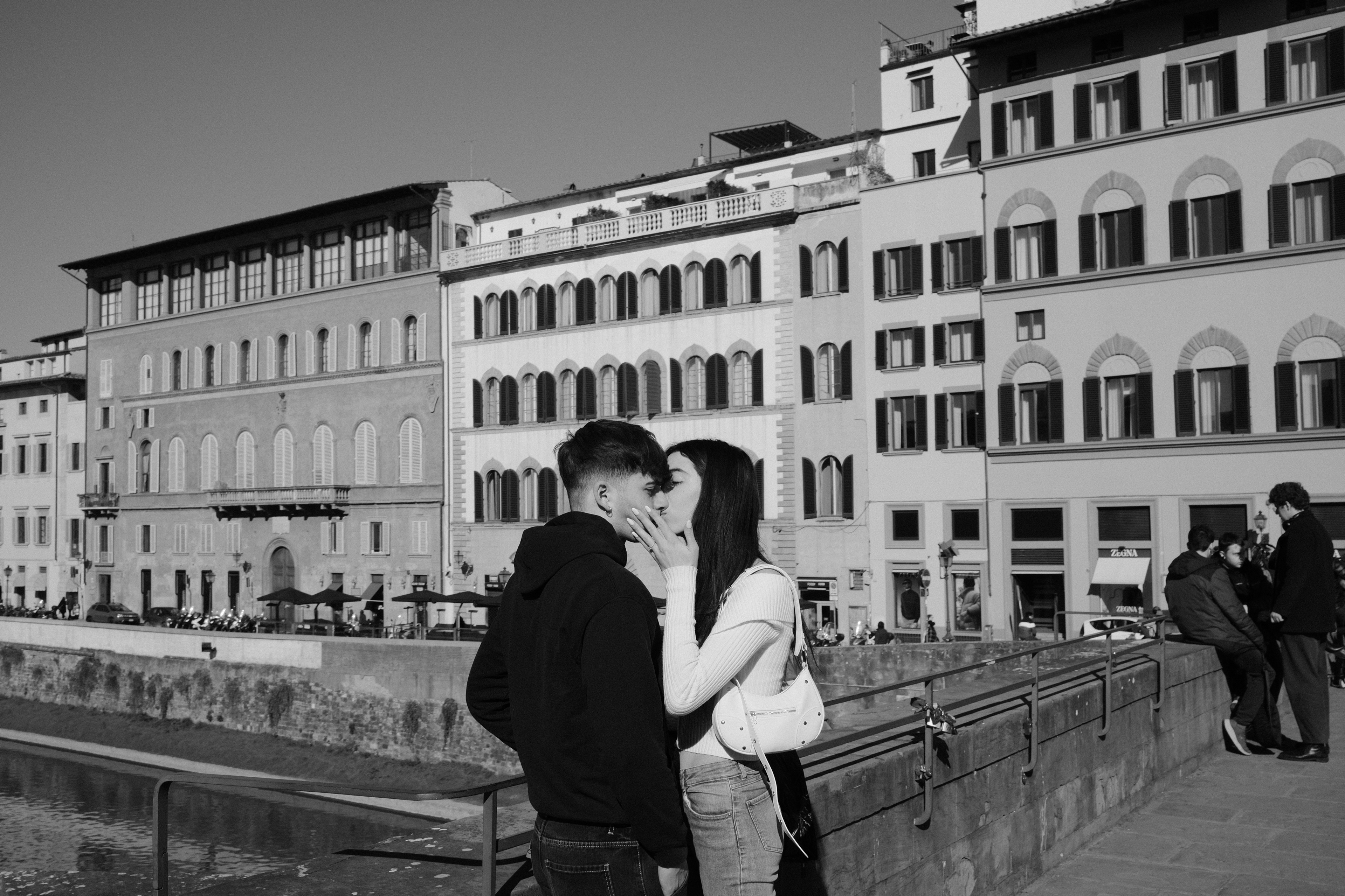 Girl kissing boy on Ponte a Santa Trinita. Florence, Italy 2024.