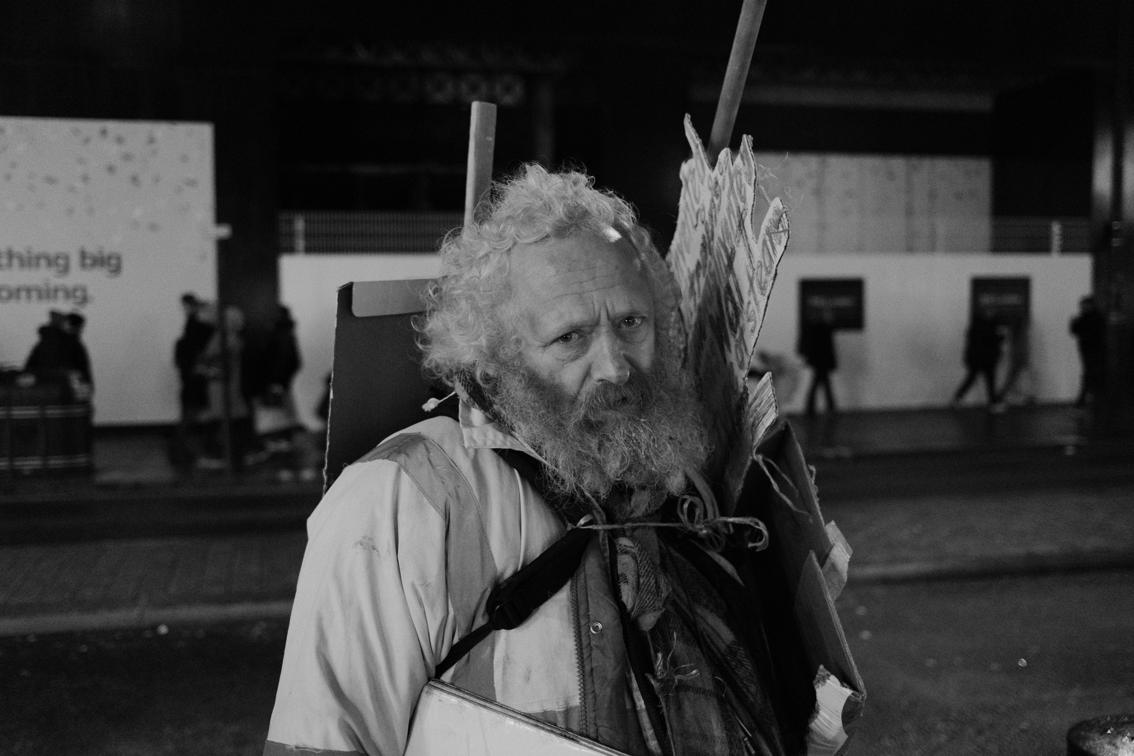 Bearded man holding cardboard signs. London, England 2024.