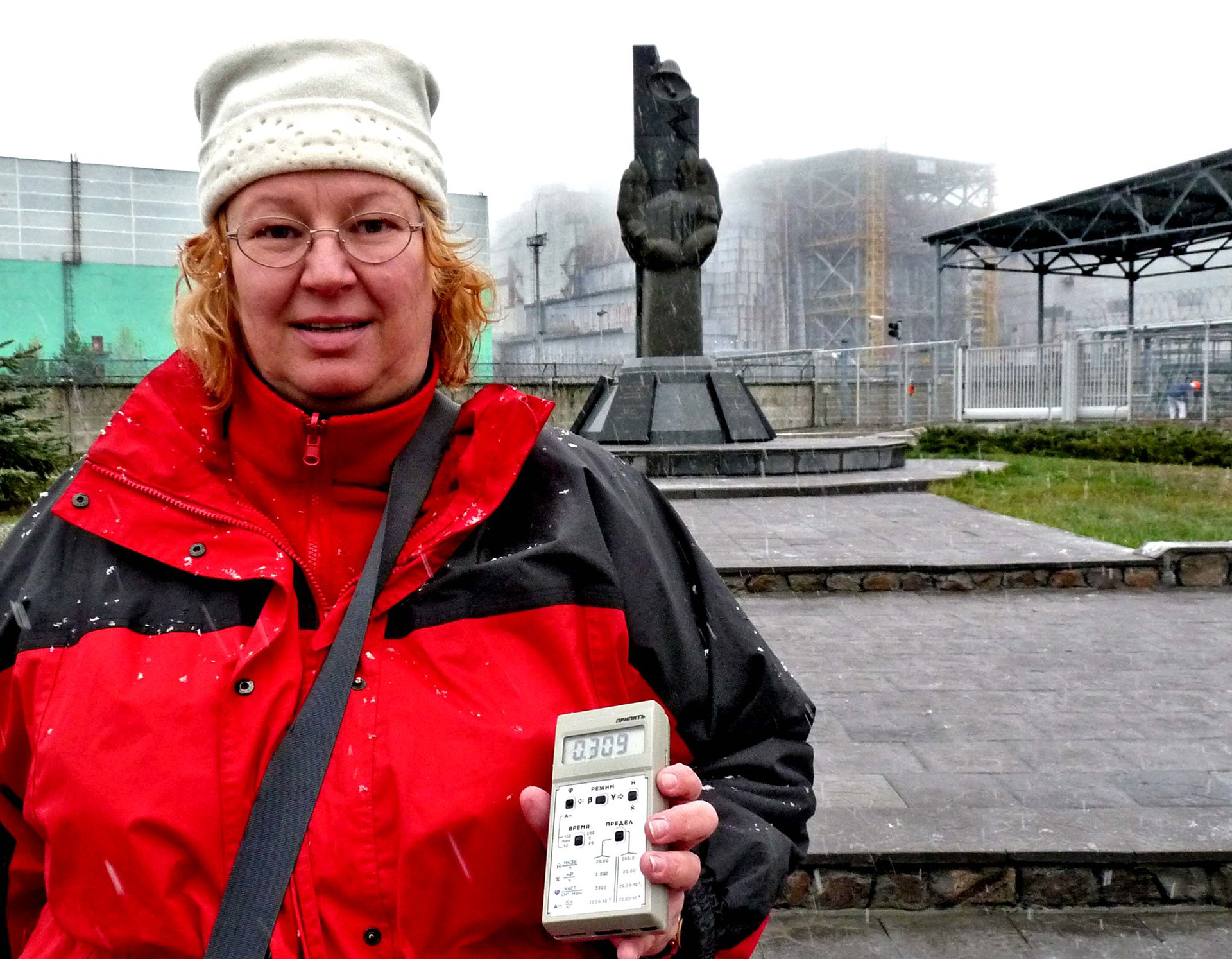 Holding a Geiger counter to measure the radiation in front of the offending reactor at Chernobyl
