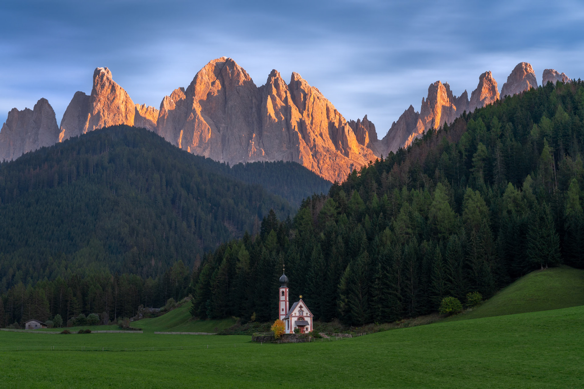 The golden light of the setting sun kisses the peaks above the Church of San Giovanni in Ranui, in the South Tyrol region of the Dolomites.