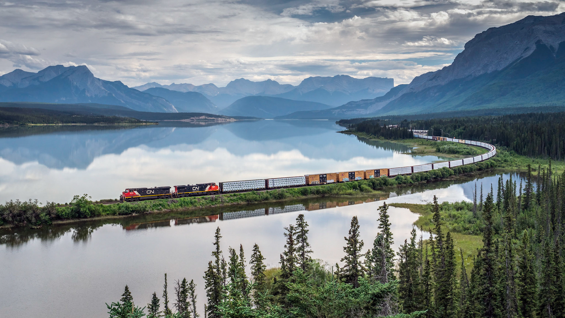 A Canadian National train rounds a long curve as it makes its way through the Rockies.