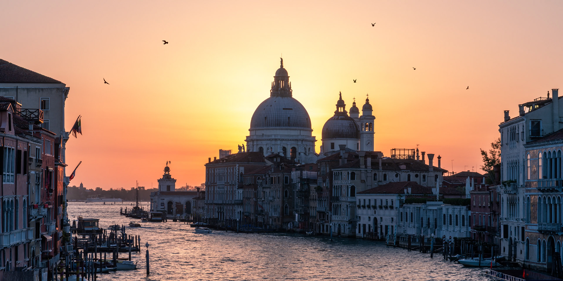 The sun rises behind the Basilica di Santa Maria della Salute in Venice.