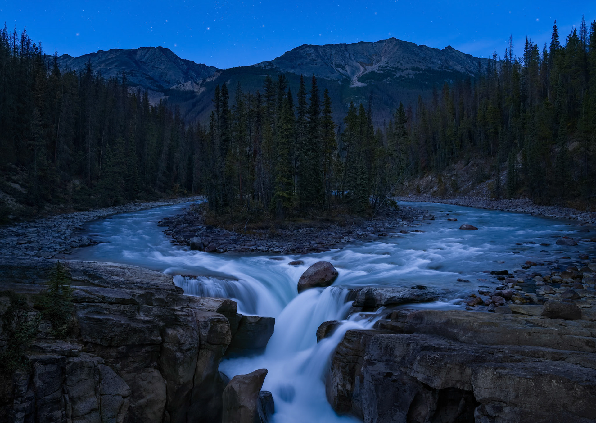 The fast-flowing glacier waters temporarily part ways, then reunite, creating nature’s perfect circle. But just as the ring of water forms, it transforms, and takes spectacular new shape as it spills over the rocks and plunges into the deep canyon far below.