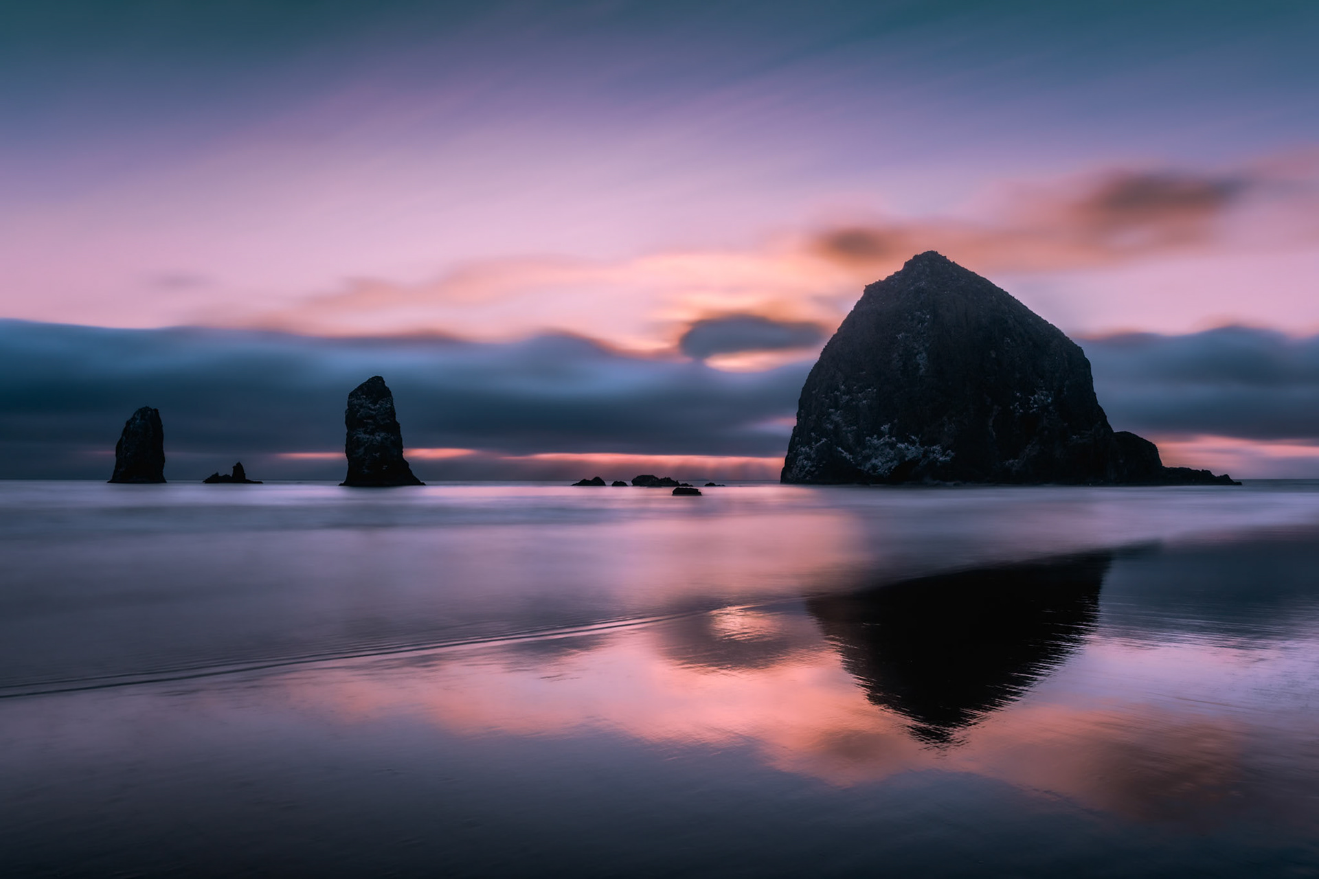 Haystack Rock and sons winding down for the night as the sun sets off Cannon Beach, Oregon.