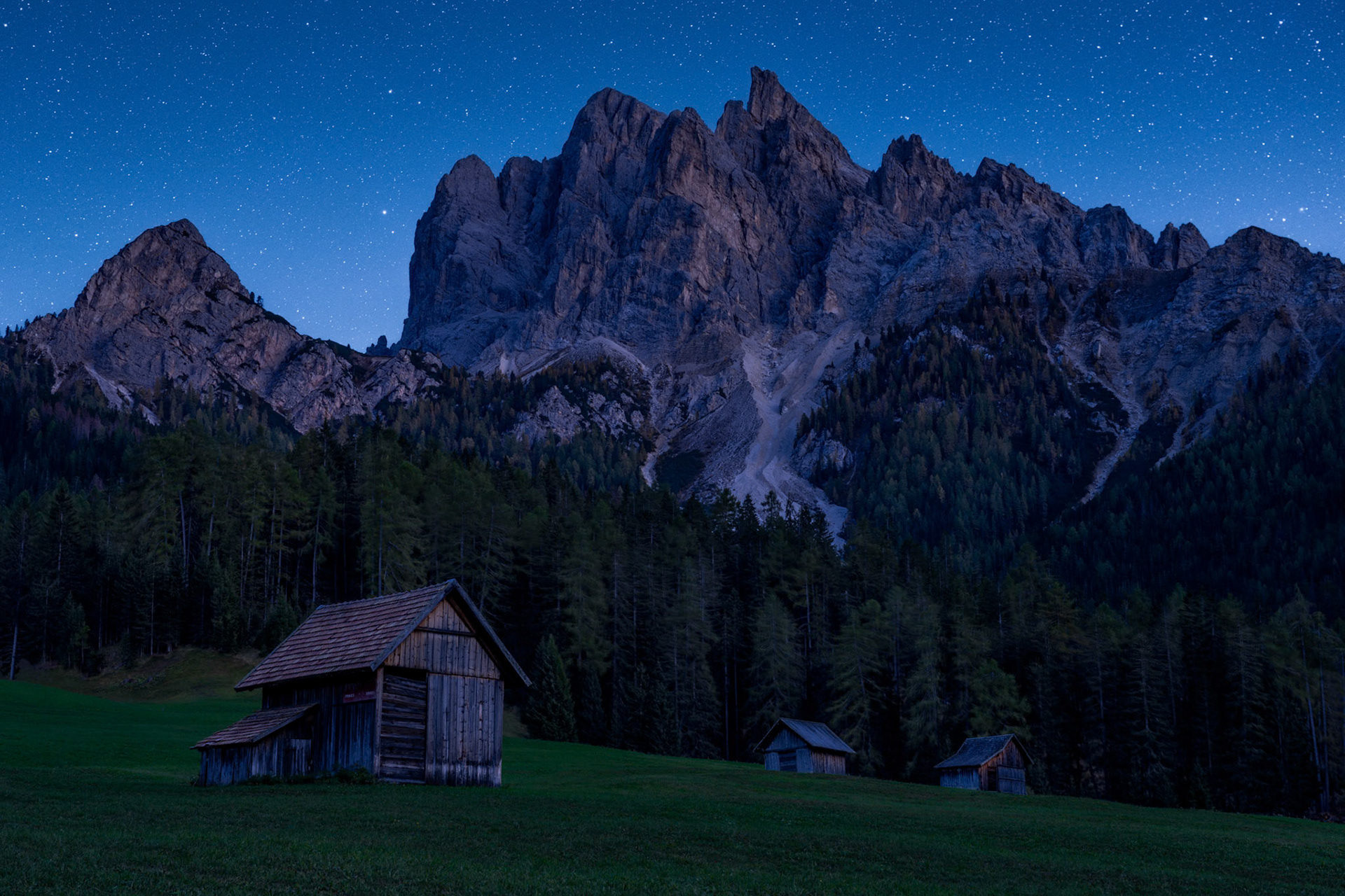A trio of mountain huts adorn the landscape in the Dolomites.