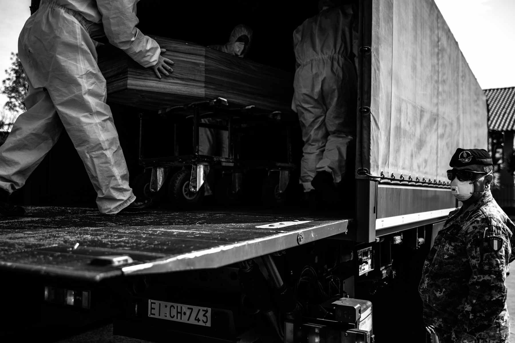 The army loading the coffins into one of their trucks