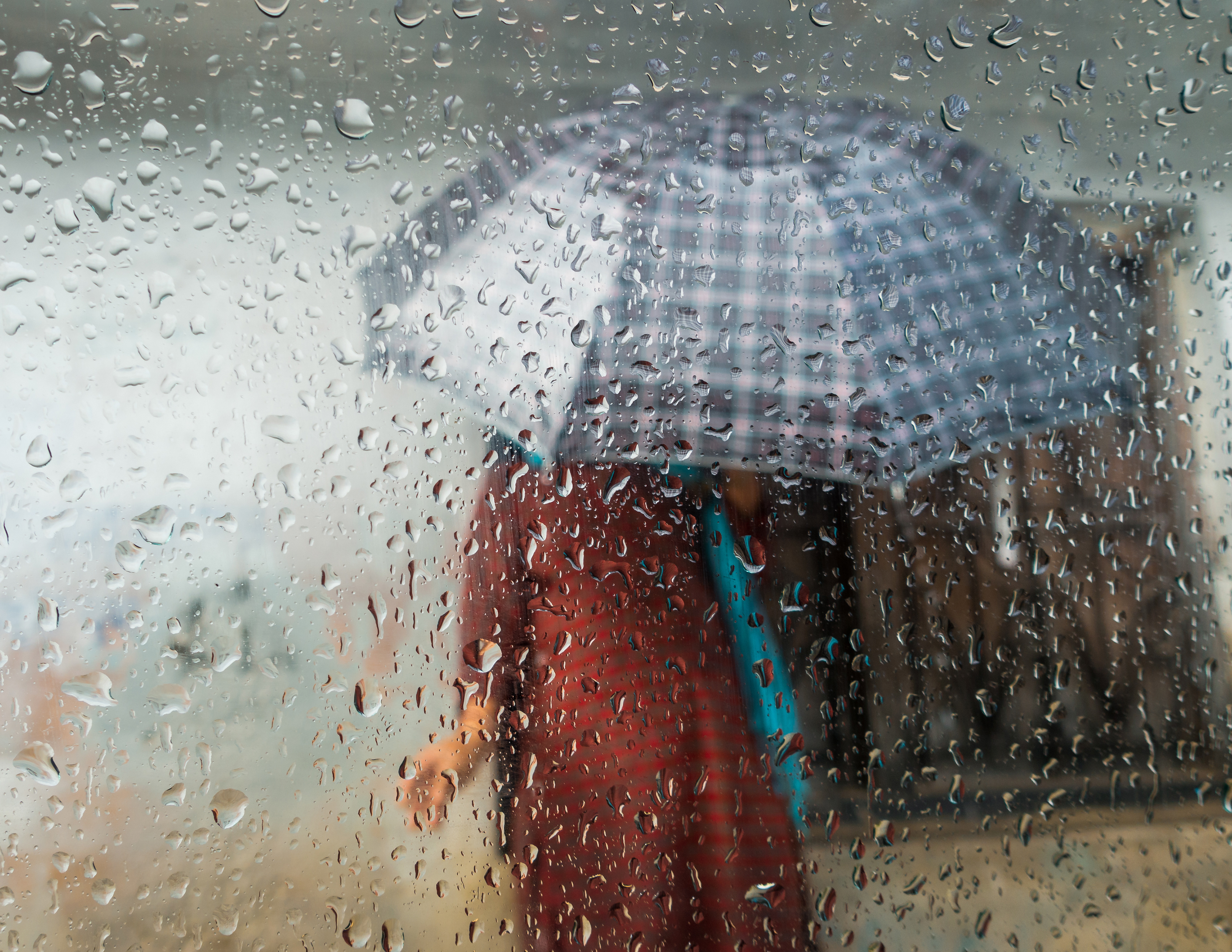 Woman holding an umbrella seen through a car window. Monsoon season in Kathmandu, Nepal. 
