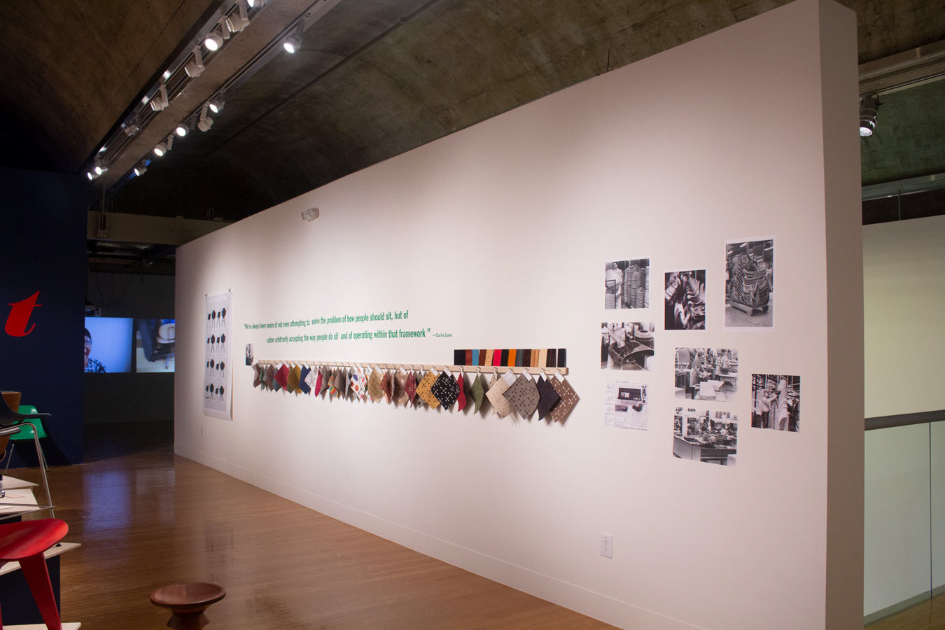 An image of the "interactive" wall, displaying different textiles and images of the Charles & Ray Eames working.