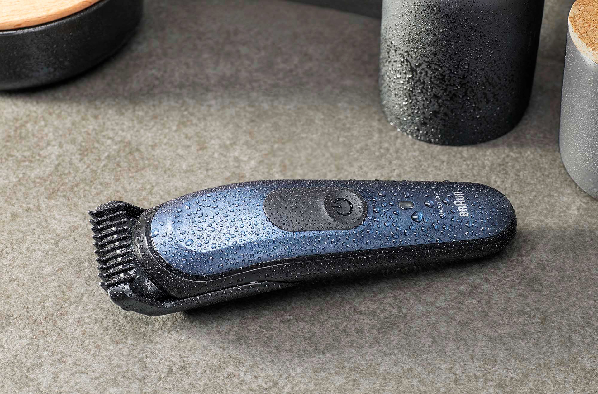 Produktaufnahme eines Barttrimmer der Marke Braun mit Wassertropfen auf einer Kachel mit Accessoires im Hintergrund. Studio für Produktfotografie - Fotograf Klaus Ohlenschläger Frankfurt Kronberg Bad Homburg