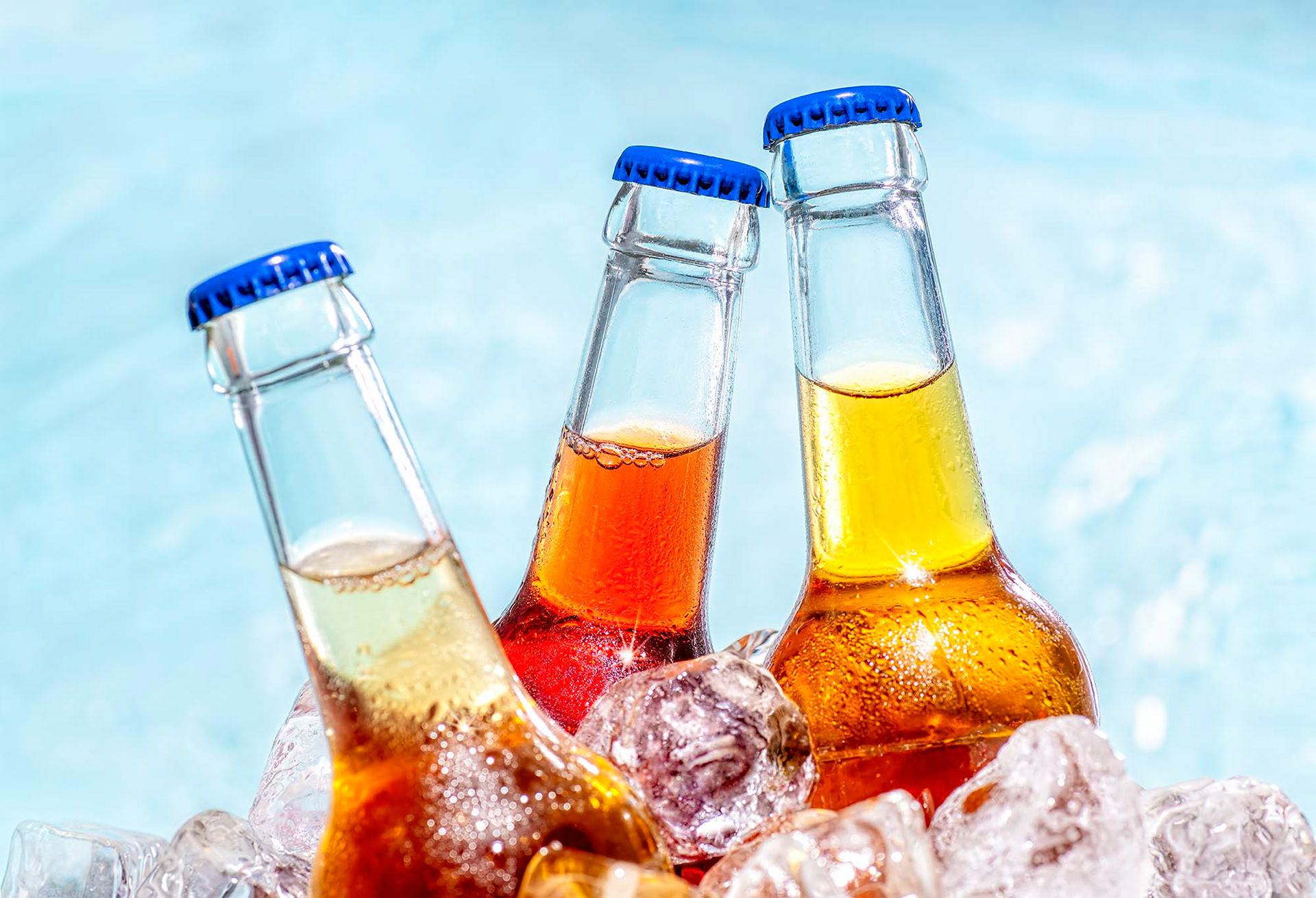 Drei Flaschen Limonade mit Eiswürfeln bedeckt mit dem Wasser eines Pools im Hintergrund. Studio für Produktfotografie in Kronberg im Taunus - Fotograf Frankfurt Klaus Ohlenschläger