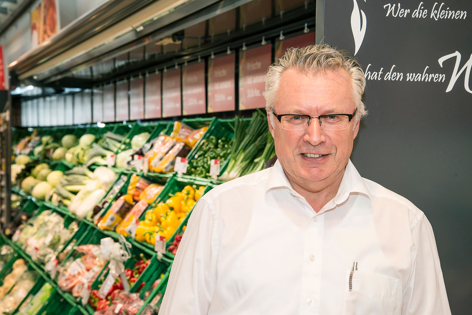 Inhaber eines Supermarktes in der Obst- und Gemüseabteilung