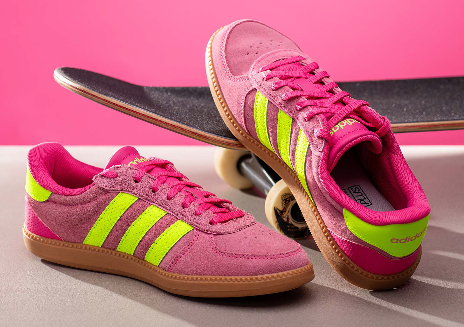 Produktfoto von Sportschuhen in Pink, von denen einer an ein Skateboard gelehnt ist und der andere links davor steht. Studio für Produktfotografie - Fotograf Klaus Ohlenschläger Frankfurt – Kronberg – Bad Homburg