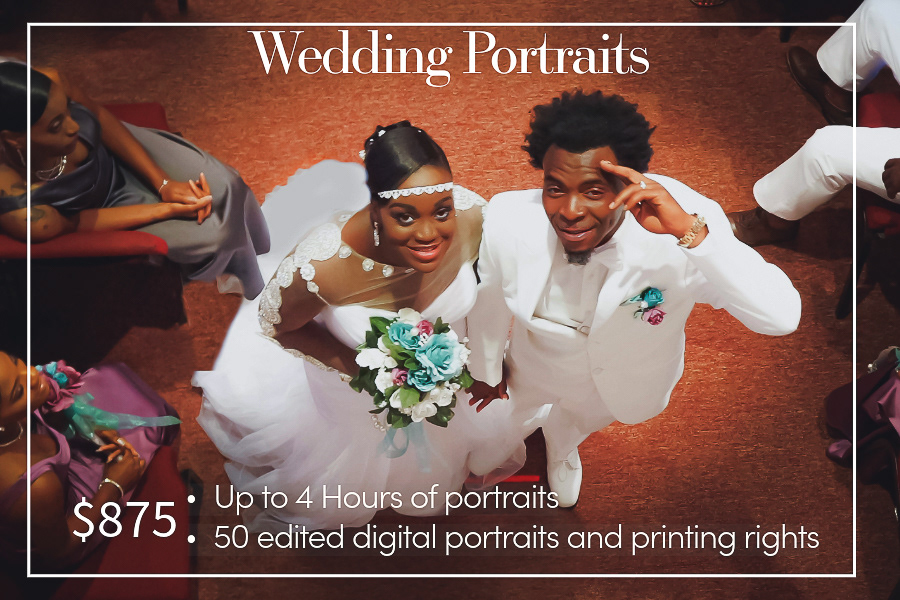 Bride and groom look overhead smiling big. They are surrounded by pews of men and women who look excited and also smile big.
