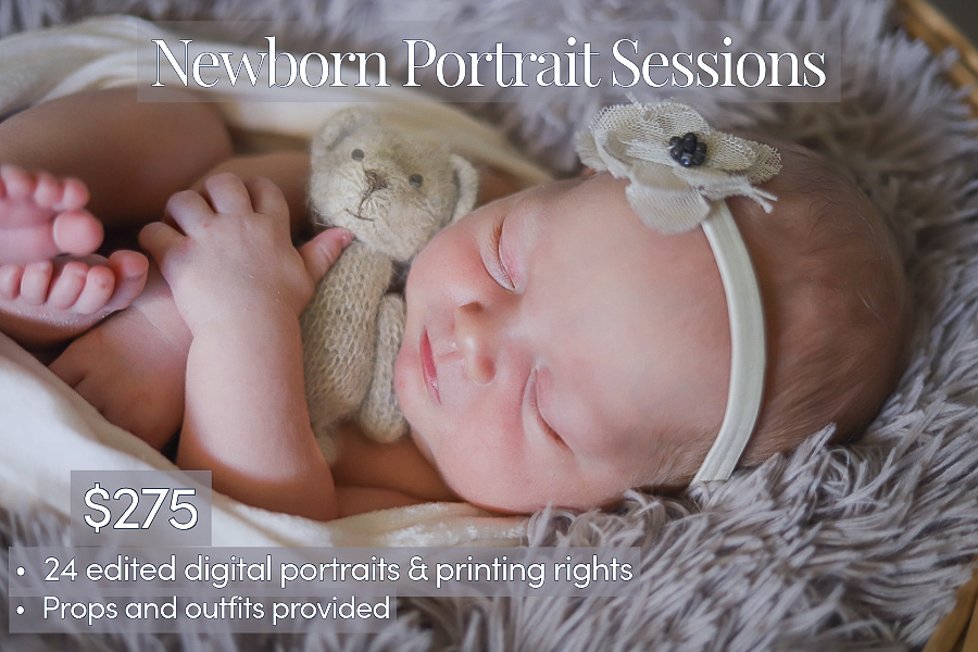 A newborn is swaddled with her feet and hands exposed and she clutches a tiny teddy bear as she sleeps.